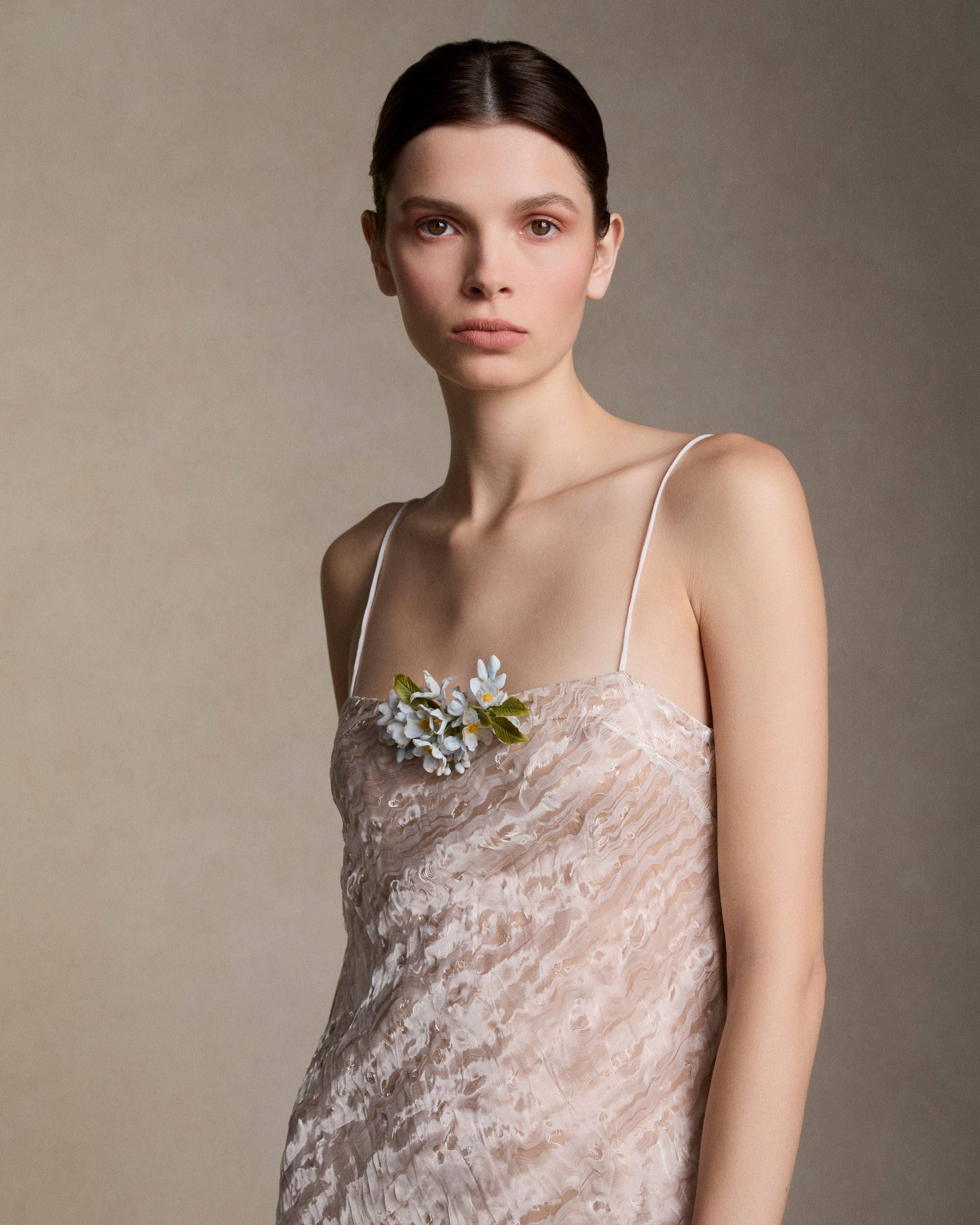 Warped transparent organza slip dress with flared hem trimmed in horsehair. Nude chiffon lining and invisible zip closure at side seam. Styled with hand crafted clay flower brooch.