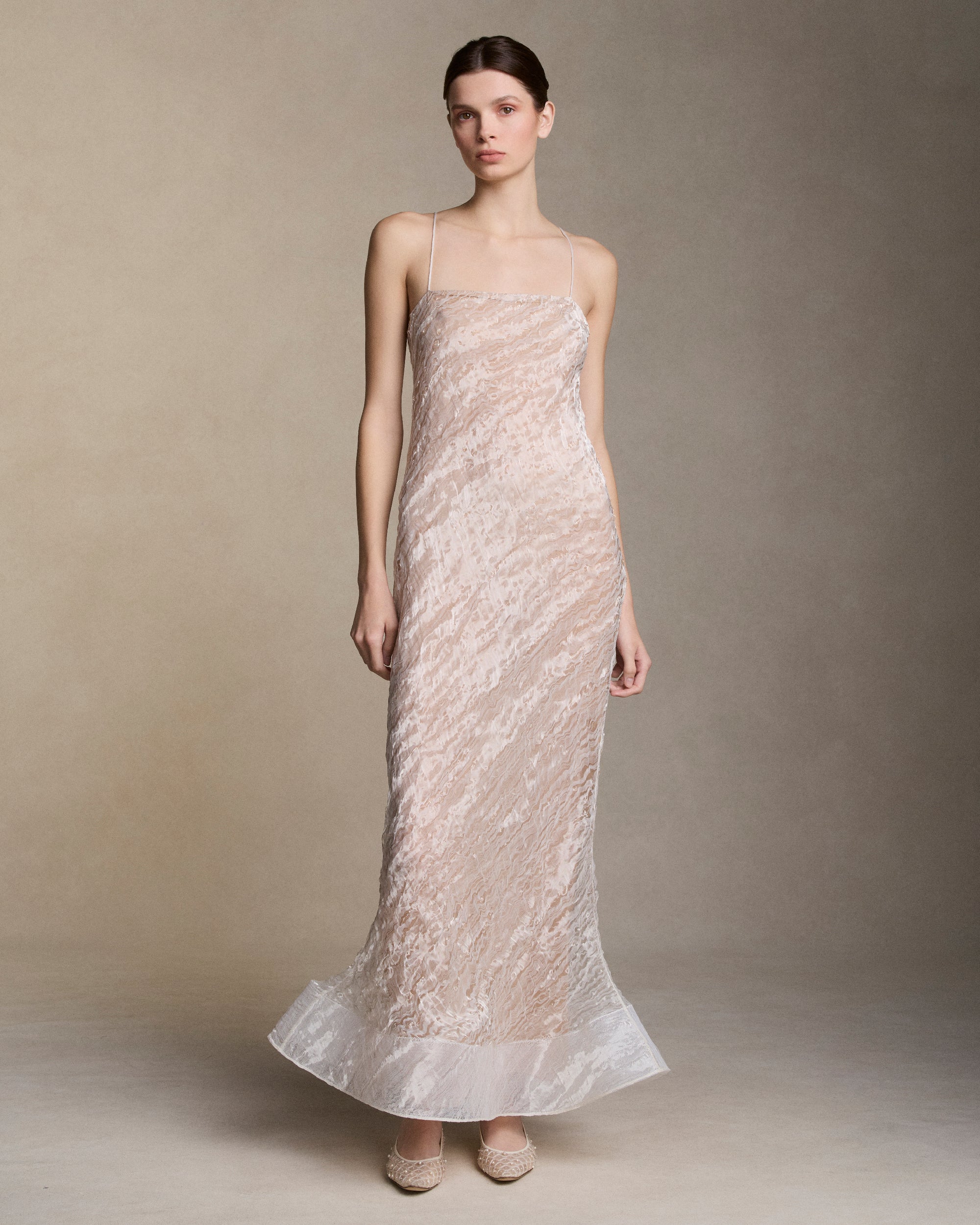 Warped transparent organza slip dress with flared hem trimmed in horsehair. Nude chiffon lining and invisible zip closure at side seam. Styled with hand crafted clay flower brooch.