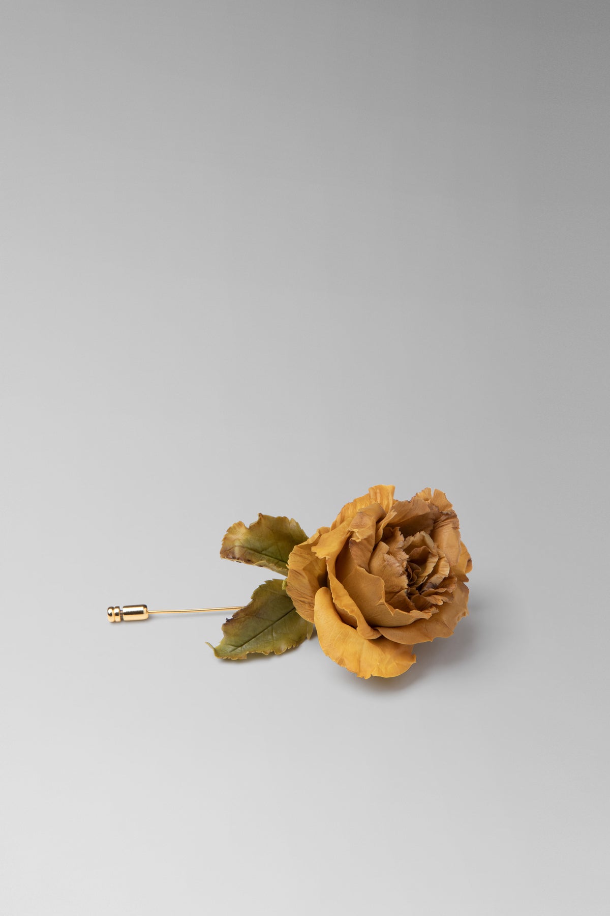 Individually hand shaped and painted clay flower brooch. Feather weight with brass head pin.Rose measures approximately H: 3¼ ” x W: 2 ¼”. 3” long brass head pin.Due to the hand made nature of the individual petals, each piece will vary slightly in size. 