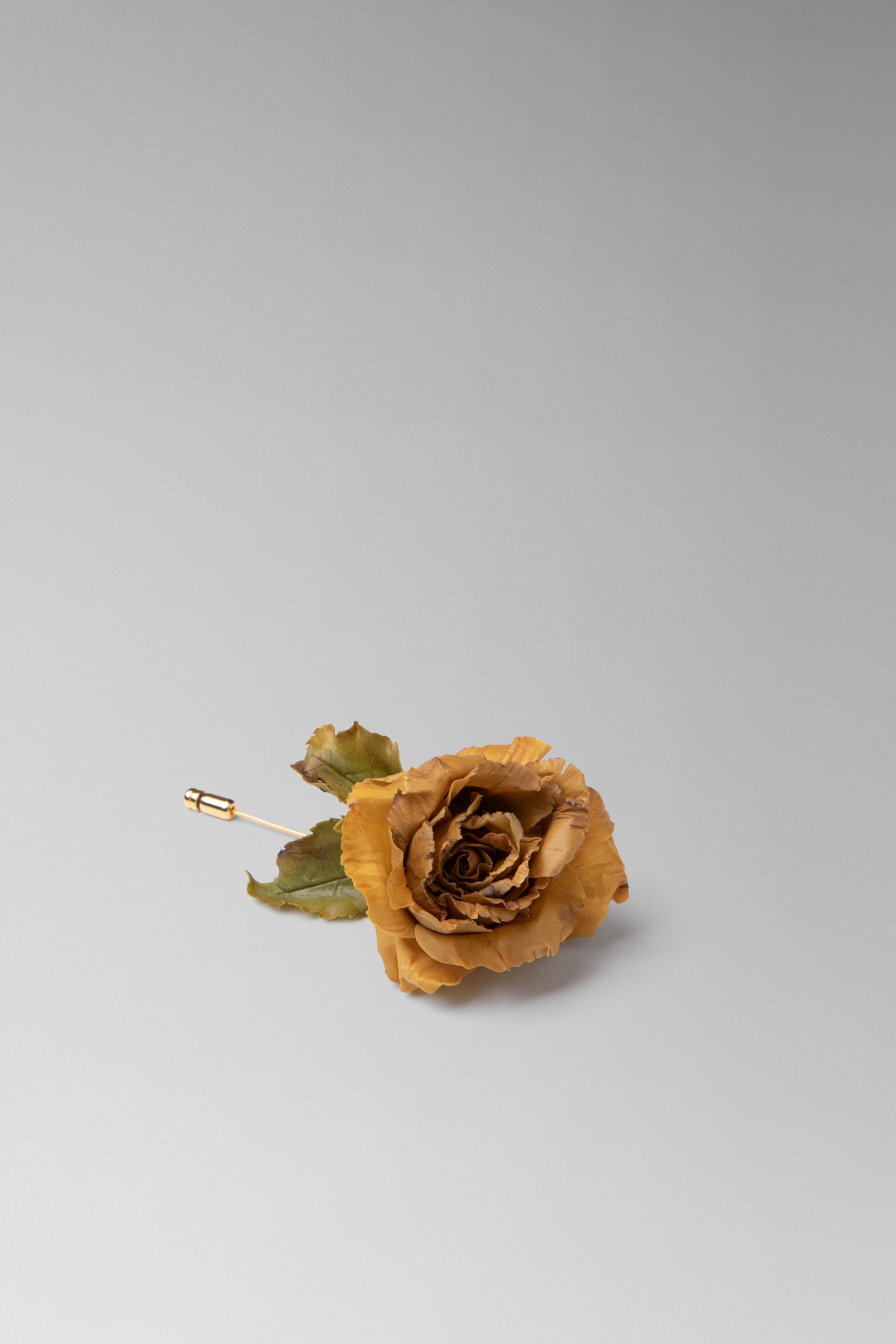 Individually hand shaped and painted clay flower brooch. Feather weight with brass head pin.Rose measures approximately H: 3¼ ” x W: 2 ¼”. 3” long brass head pin.Due to the hand made nature of the individual petals, each piece will vary slightly in size. 