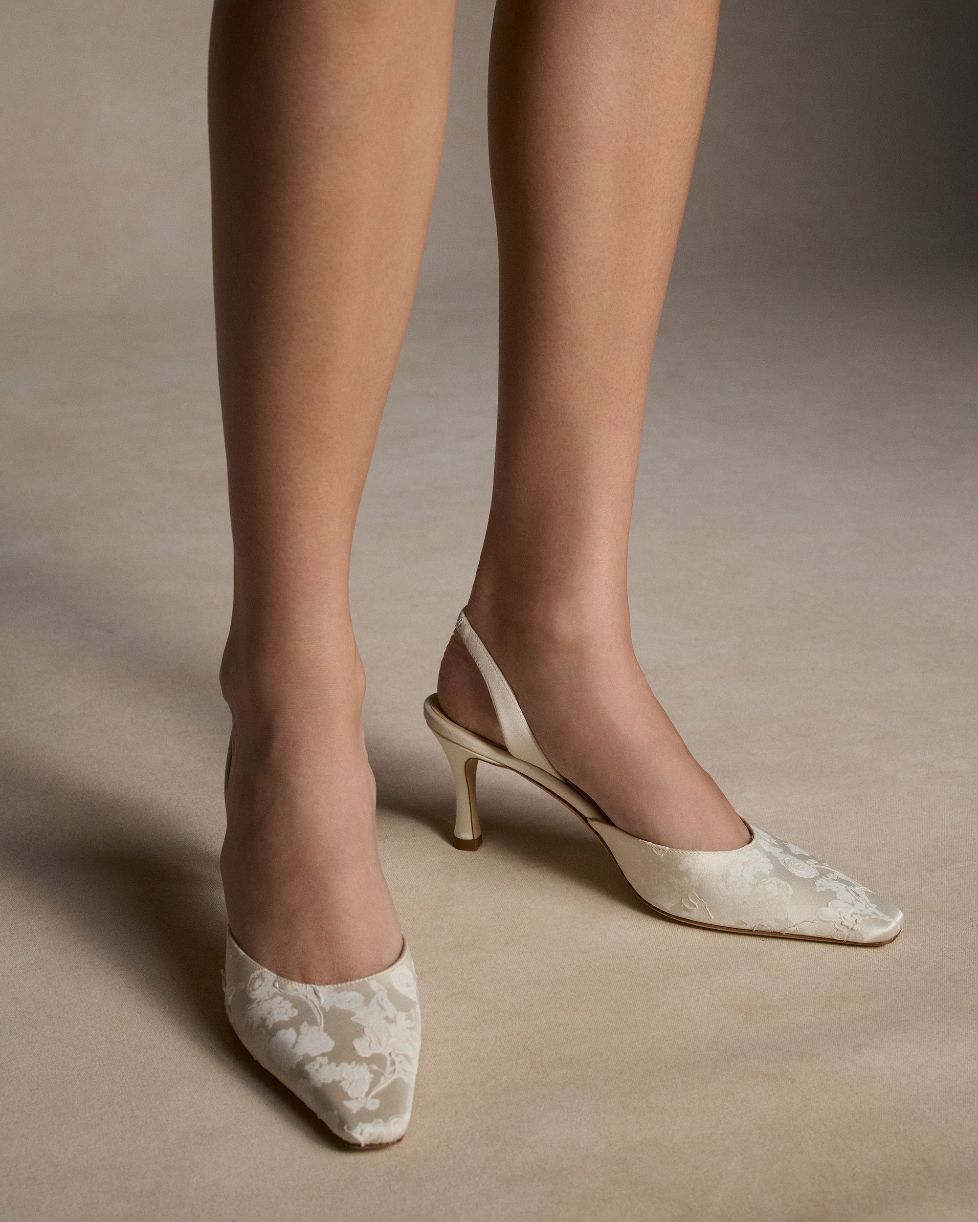 Classic slingback crafted in Italy of pigment printed &amp; hand painted ivory satin. Elongated round toe and 75mm heel.