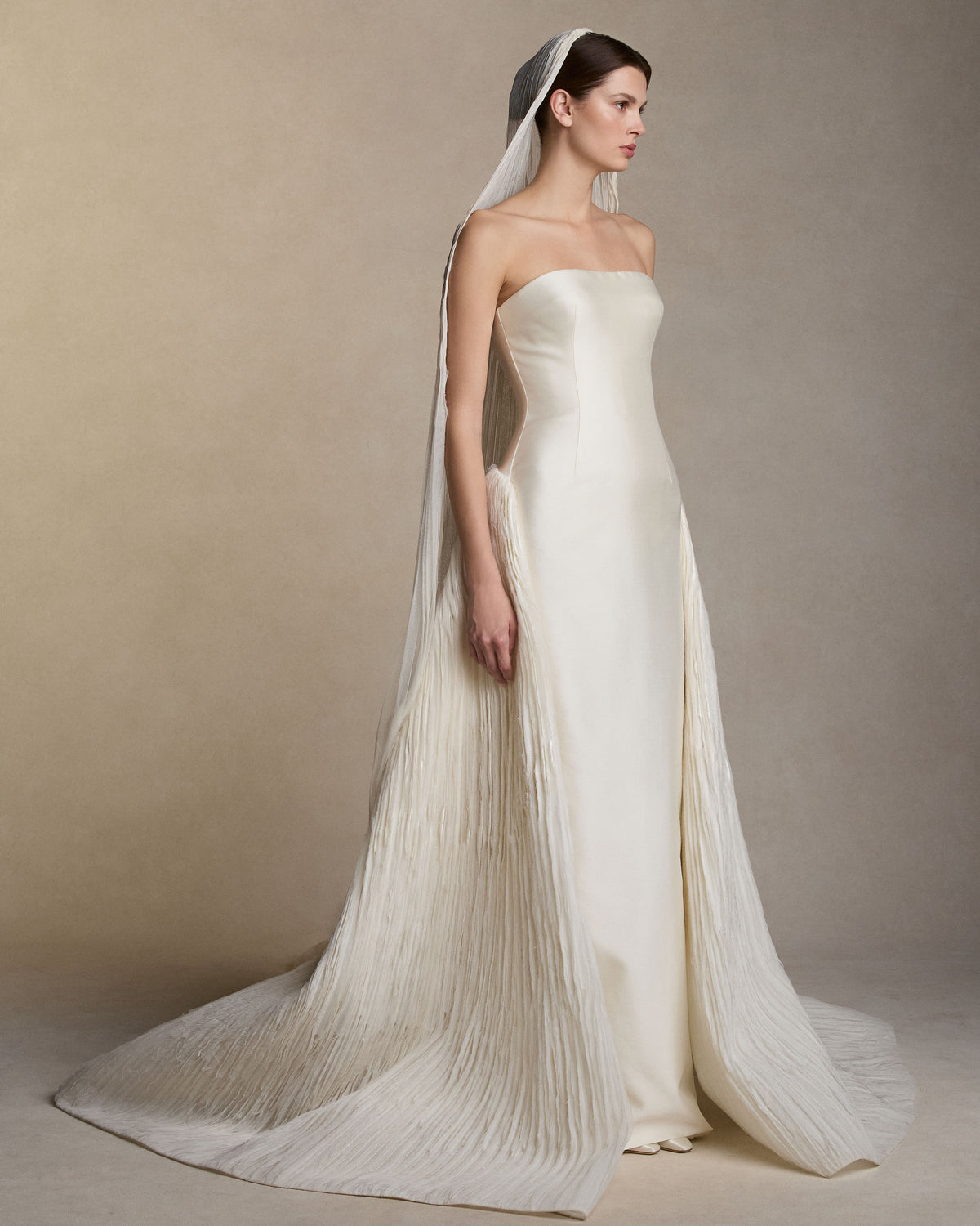Pleated soft tulle veil. Tulle gathered into comb. Undulating hem measures 120” at longest point from comb