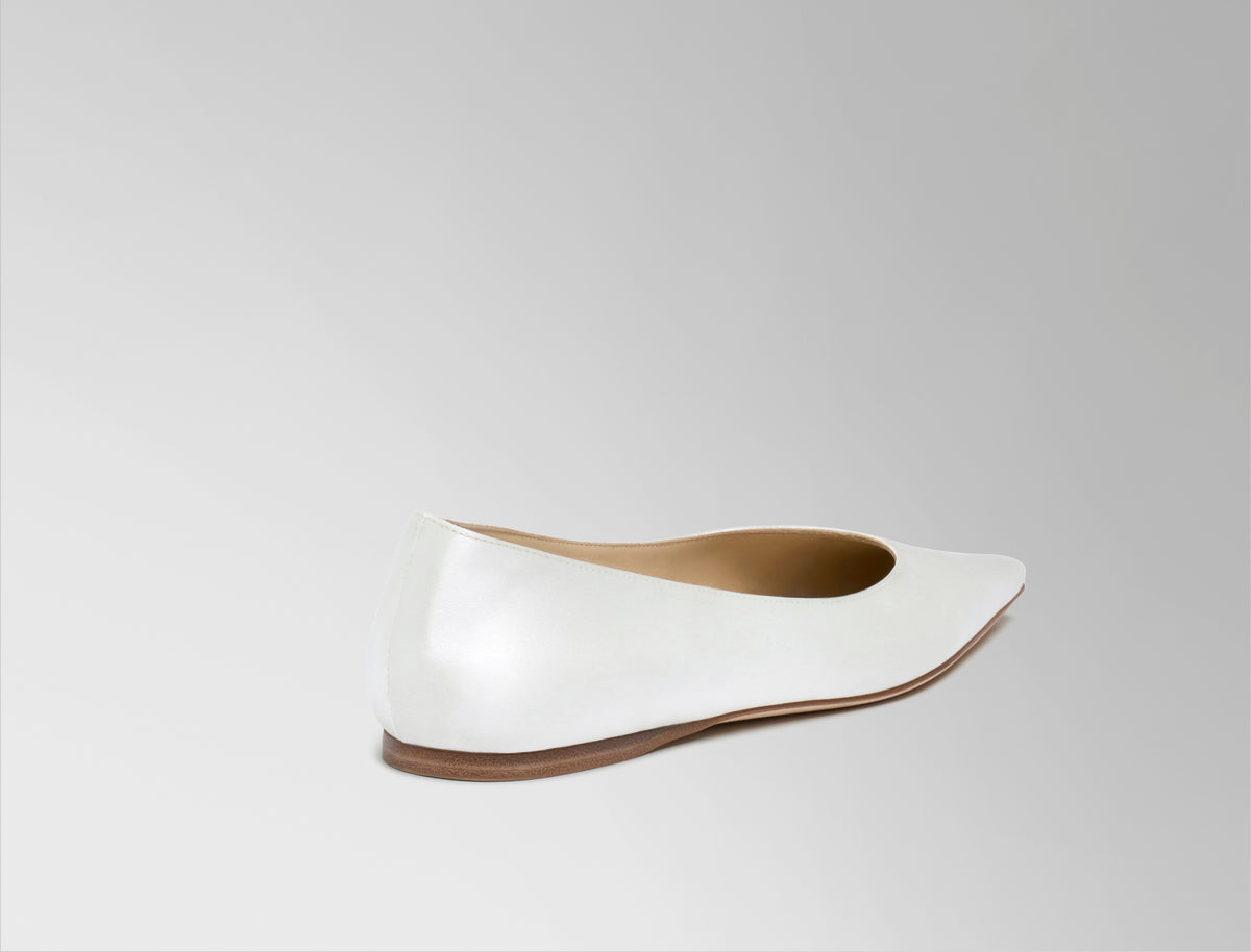 Classic elongated round toe ballerina flat crafted in Italy of ivory satin.