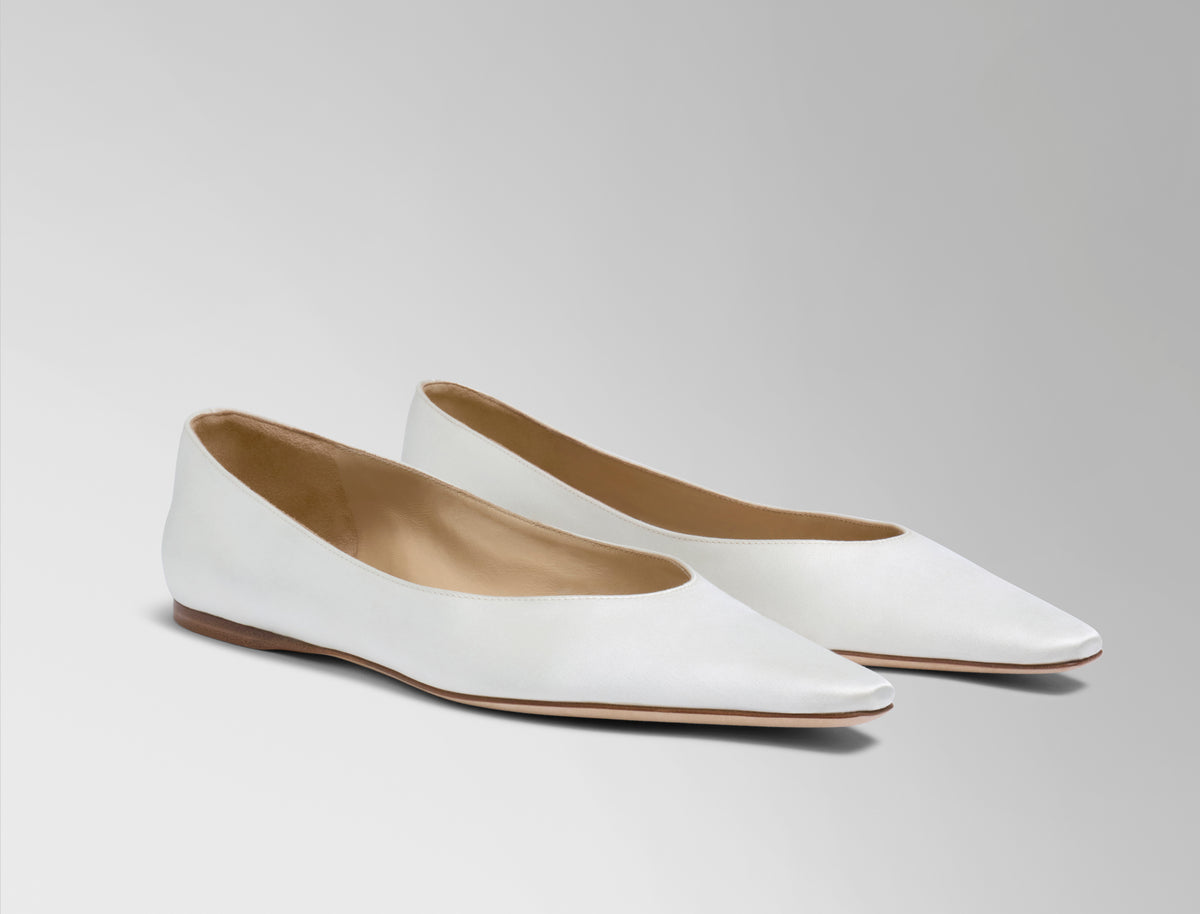 Classic elongated round toe ballerina flat crafted in Italy of ivory satin.
