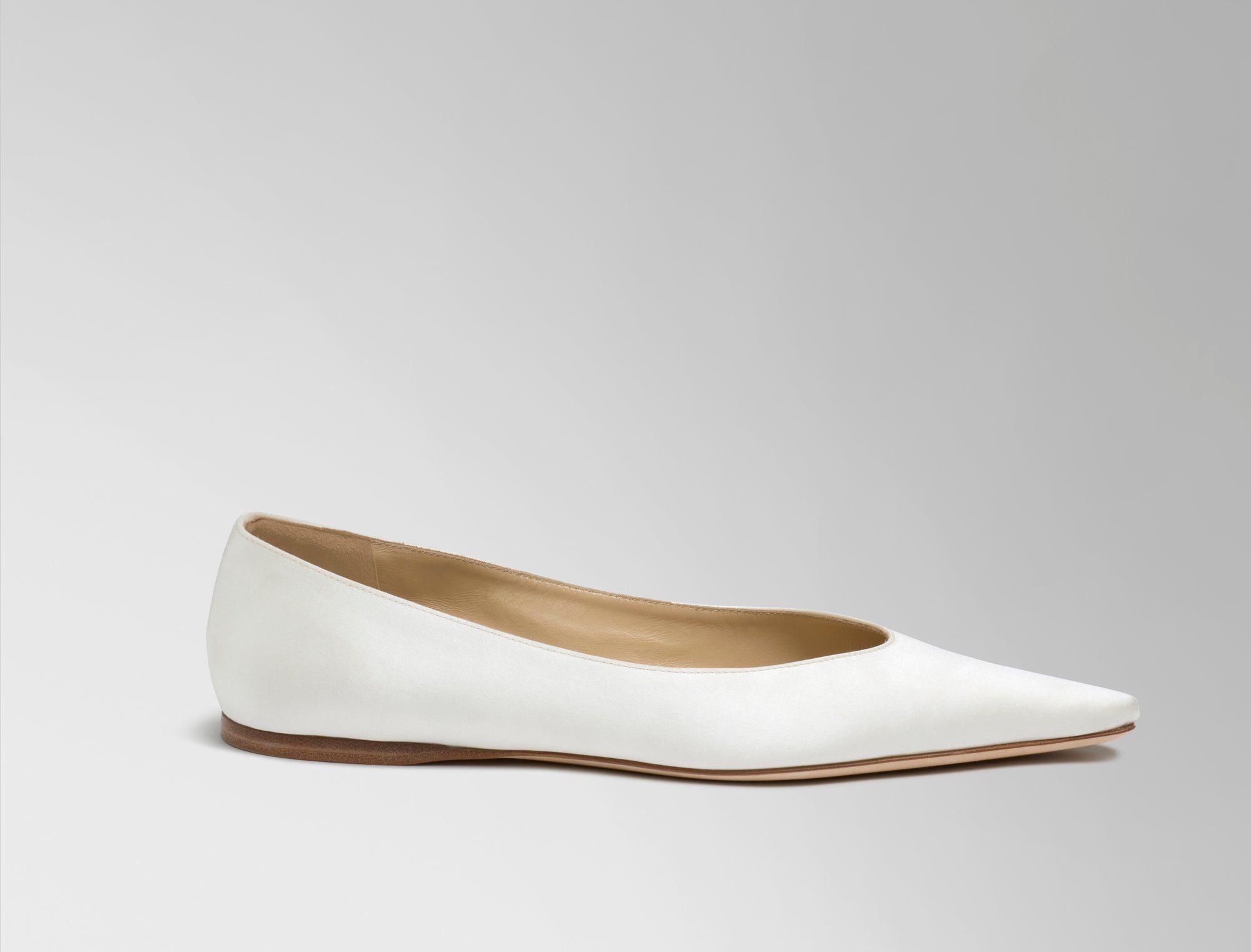 Classic elongated round toe ballerina flat crafted in Italy of ivory satin.
