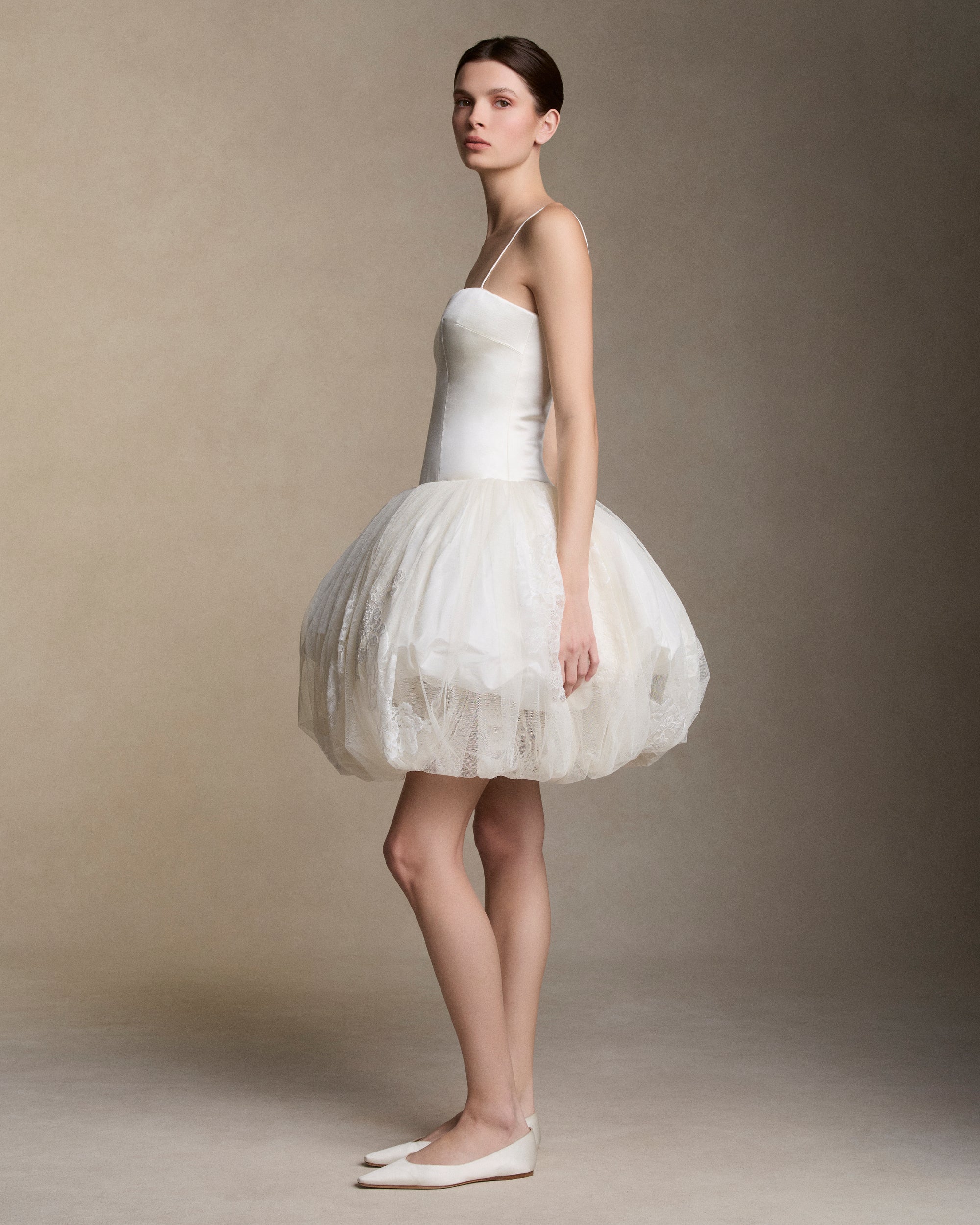 Silk wool drop waist mini dress with layered silk taffeta and soft tulle  bubble skirt adorned with hand cut chantilly and lace appliques. Straight neckline with spaghetti straps. Boned internal bustier, internal grosgrain belt and invisible zip closure at center back.