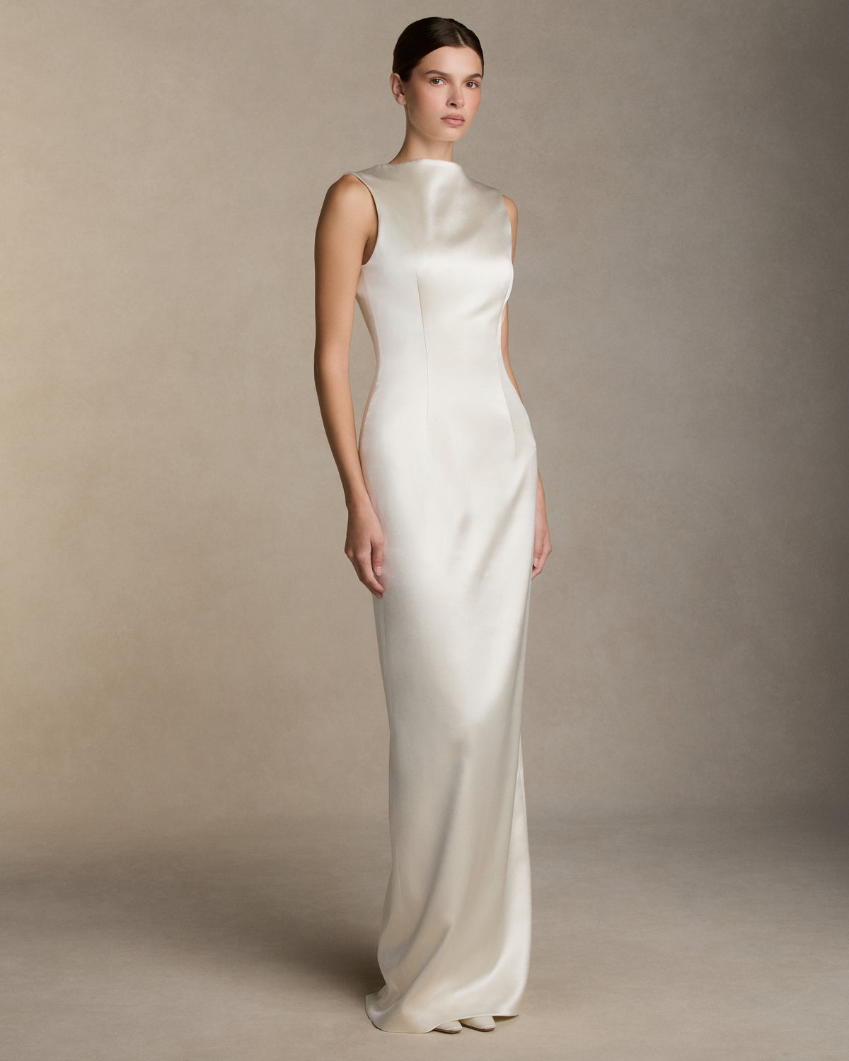 Silk wool column gown with high neckline and deep V back, featuring covered buttons down center back and back slit detail on skirt. Removable watteau train detail is suspended from the back neckline. Invisible zip closure at center back.