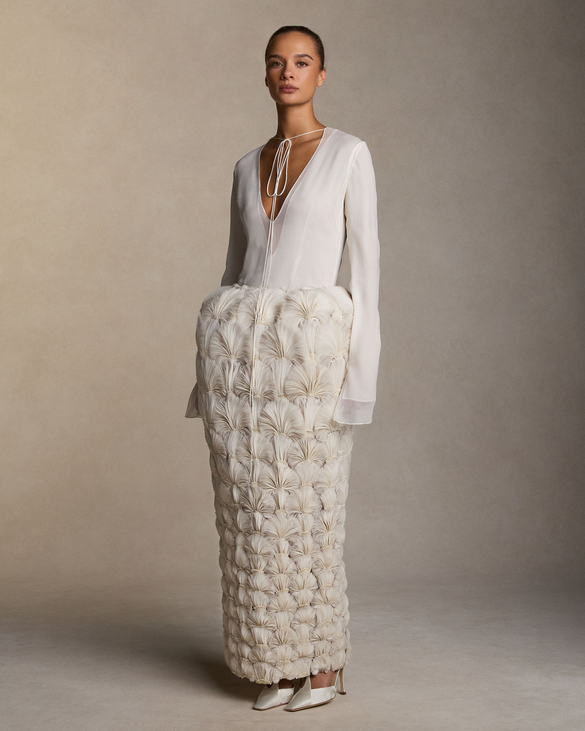 Sculptural pegged column skirt with hand-cut silk organza petal fan embroidery. Thousands of hand-applied silk organza petals, accented with hand-cut crystal beads, degrade down the skirt. Invisible zip closure at center back. Styled with Samira top