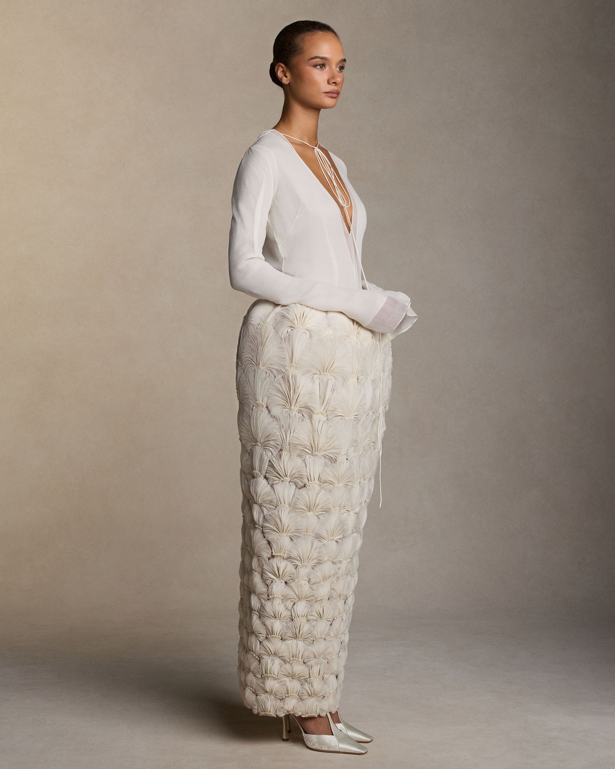 Sculptural pegged column skirt with hand-cut silk organza petal fan embroidery. Thousands of hand-applied silk organza petals, accented with hand-cut crystal beads, degrade down the skirt. Invisible zip closure at center back. Styled with Samira top