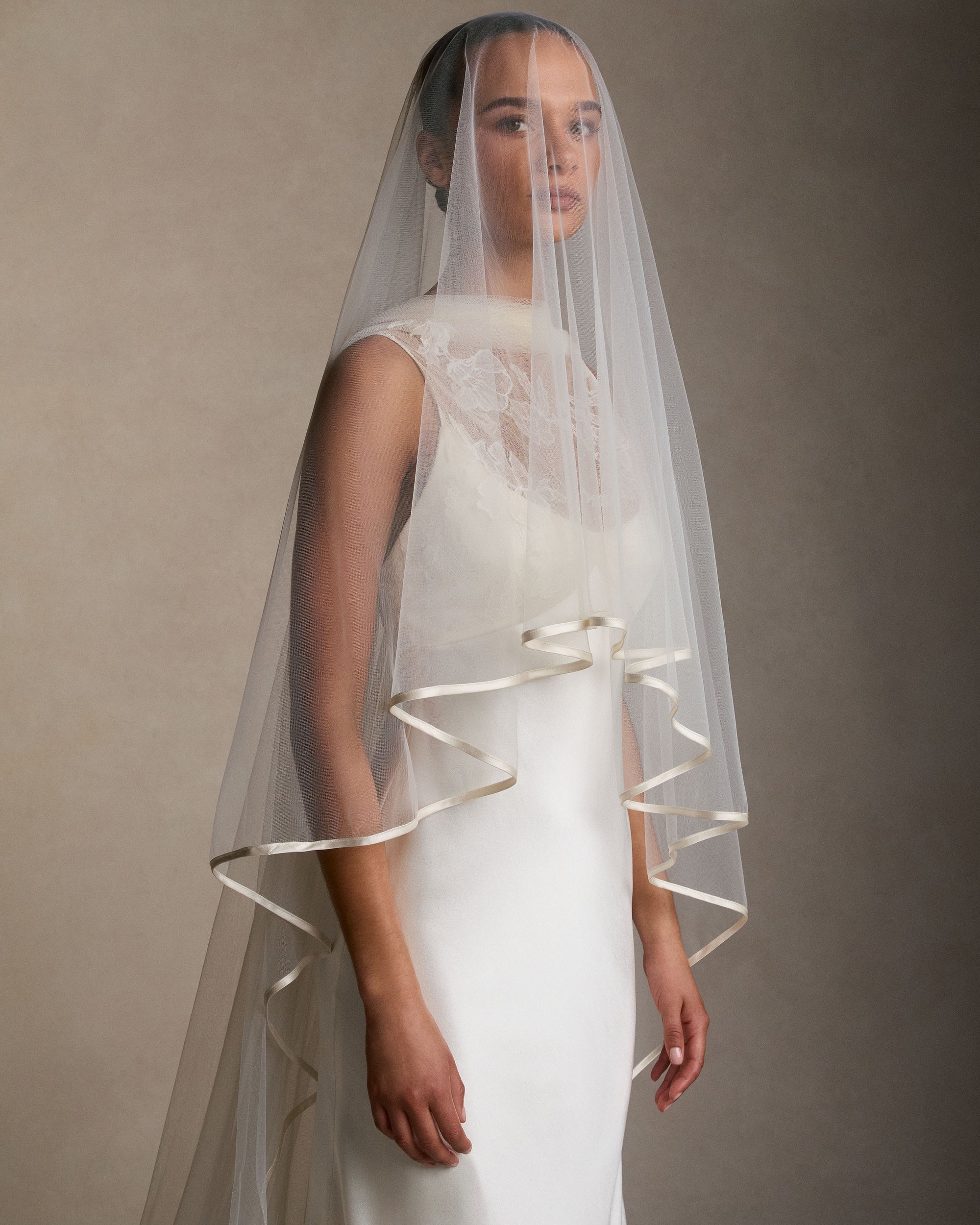 Soft Tulle veil bordered with delicate satin binding. 110" from comb with 28" blusher.