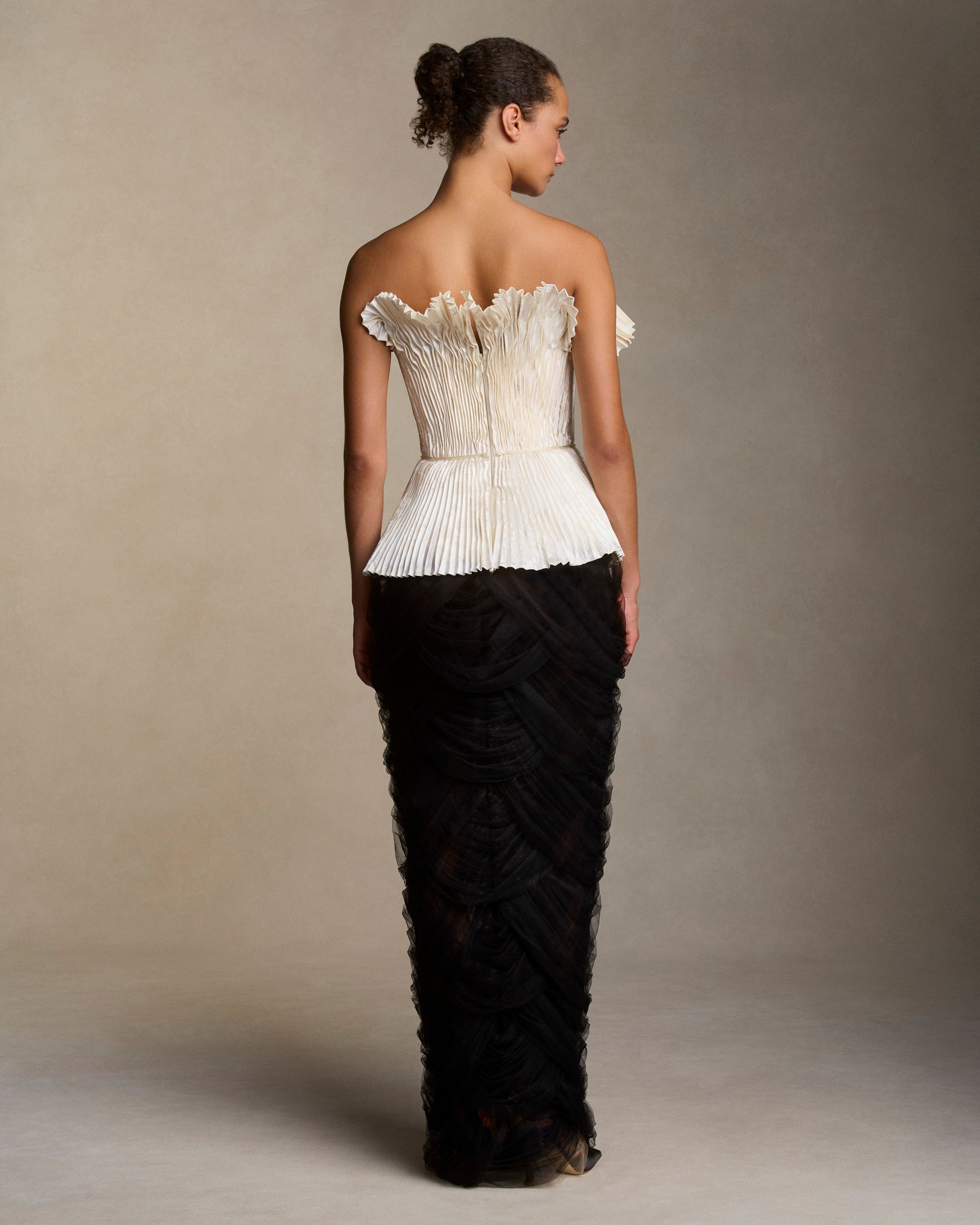 Soft tulle column skirt with layered interlocking swag drapes cascading from waist. Invisible side zip closure.Styled with Veda bustier (pearl), styled with Savannah bustier (black)