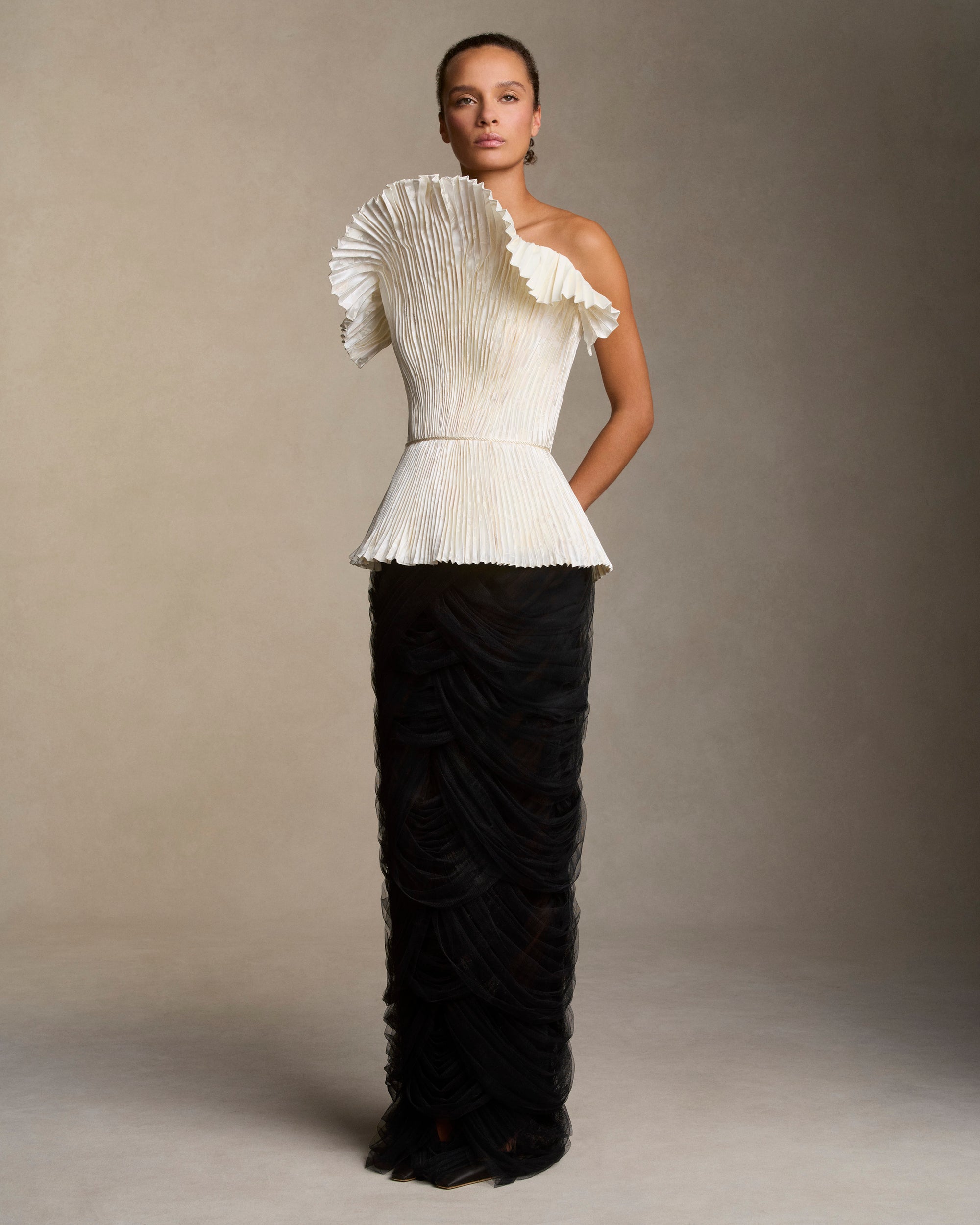 Floral pigment printed and hand painted pleated silk wool bustier with exaggerated flared neckline. Twisted cord detail at the waist, boned internal bustier, internal grosgrain belt and invisible zip closure at center back.Styled with Cosette skirt