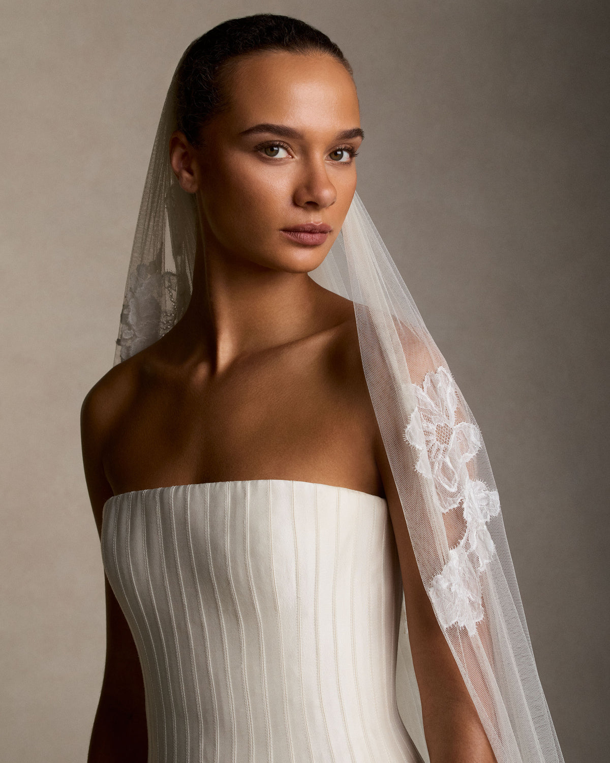 Soft tulle veil gathered into comb with hand cut & appliquéd Chantilly and corded laces scattered throughout. 120