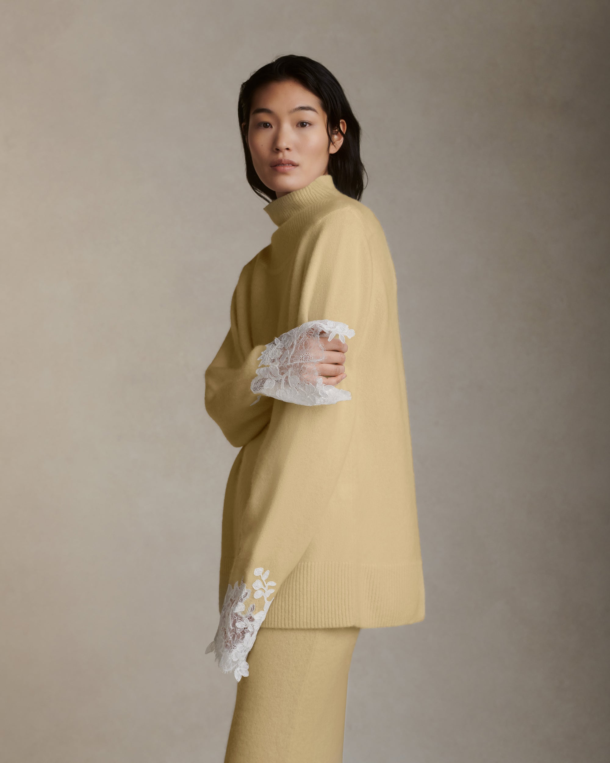 Silk cashmere slip on skirt with hand cut chantilly and corded lace applique adorning hem. Left side slit. Elasticated waist.Styled with Sid pullover