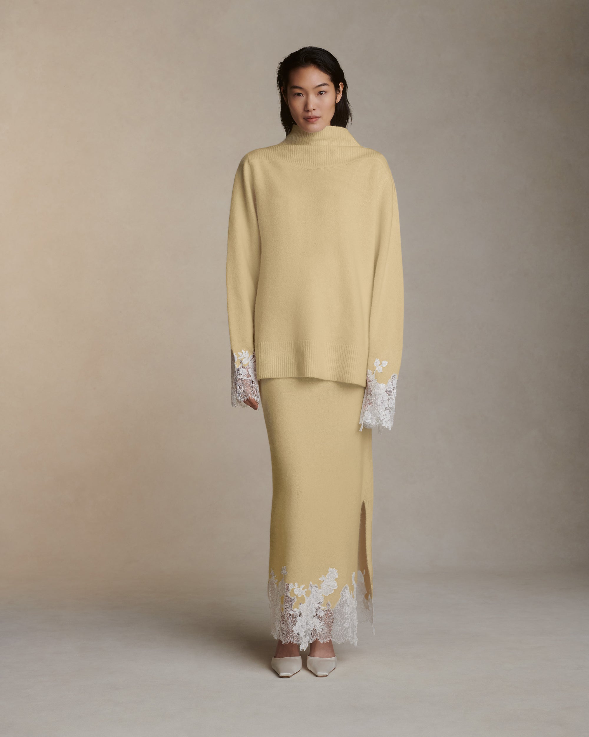 Silk cashmere slip on skirt with hand cut chantilly and corded lace applique adorning hem. Left side slit. Elasticated waist.Styled with Sid pullover