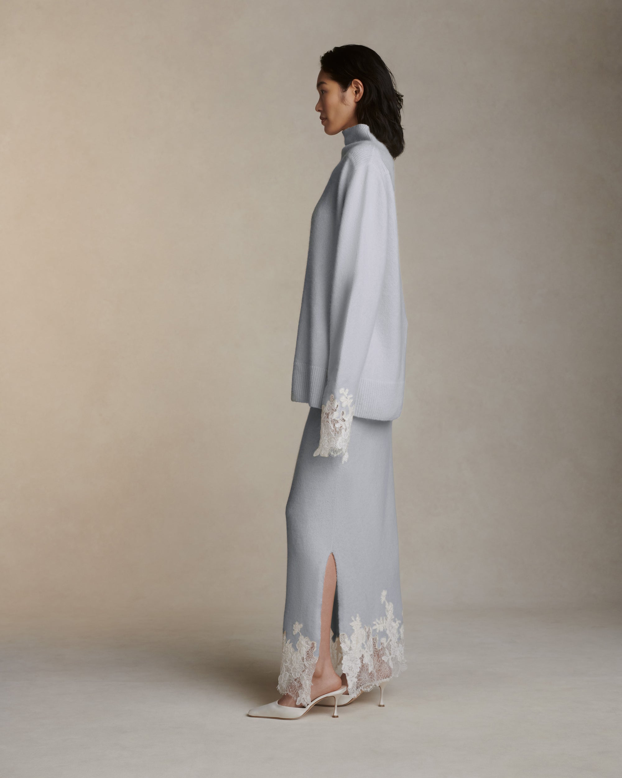 Silk cashmere slip on skirt with hand cut chantilly and corded lace applique adorning hem. Left side slit. Elasticated waist.Styled with Sid pullover