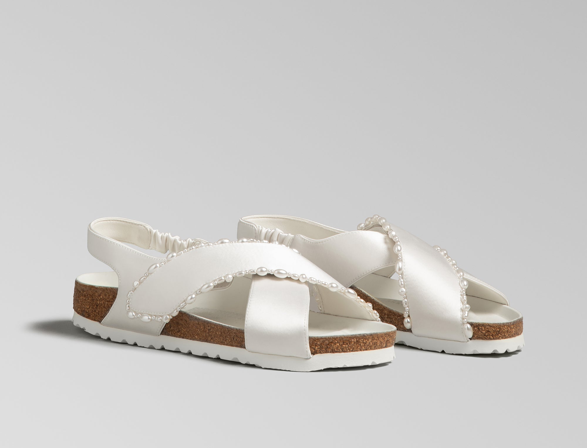 The Tulum is reimagined in a luminous ivory satin, featuring a graceful crossover profile and a slim ankle strap adorned with delicate pearls. The design also introduces an innovative adjustable hidden buckle closure. Handcrafted in Germany, the shoe merges BIRKENSTOCK’s legendary comfort with Danielle Frankel’s signature touch of refined elegance.- Upper: Delicate satin upper, naturally shaped pearls handstitched on trim- Footbed: Anatomical shaped BIRKENSTOCK cork latex Footbed lined with premium Nappa Leather- Sole: EVA die cut outsole with a custom design, blending classic BIRKENSTOCK bone pattern with delicate leaf inspired detailing