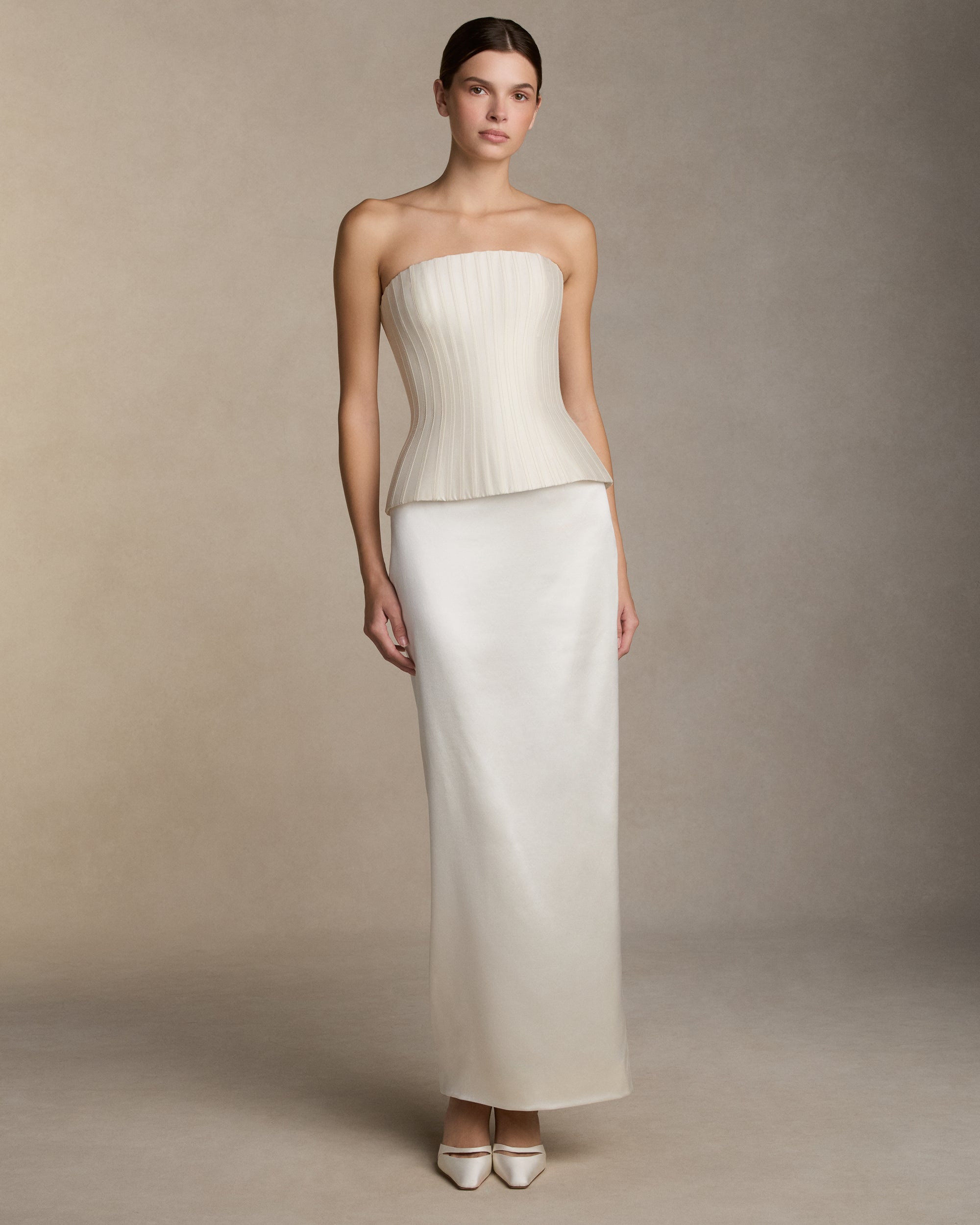 Structured silk wool twill strapless bustier with sharp waistline. Grosgrain boning detail throughout the bodice frames the silhouette. Boned internal bustier, internal grosgrain belt and invisible zip closure at center back.Styled with Tristan skirt