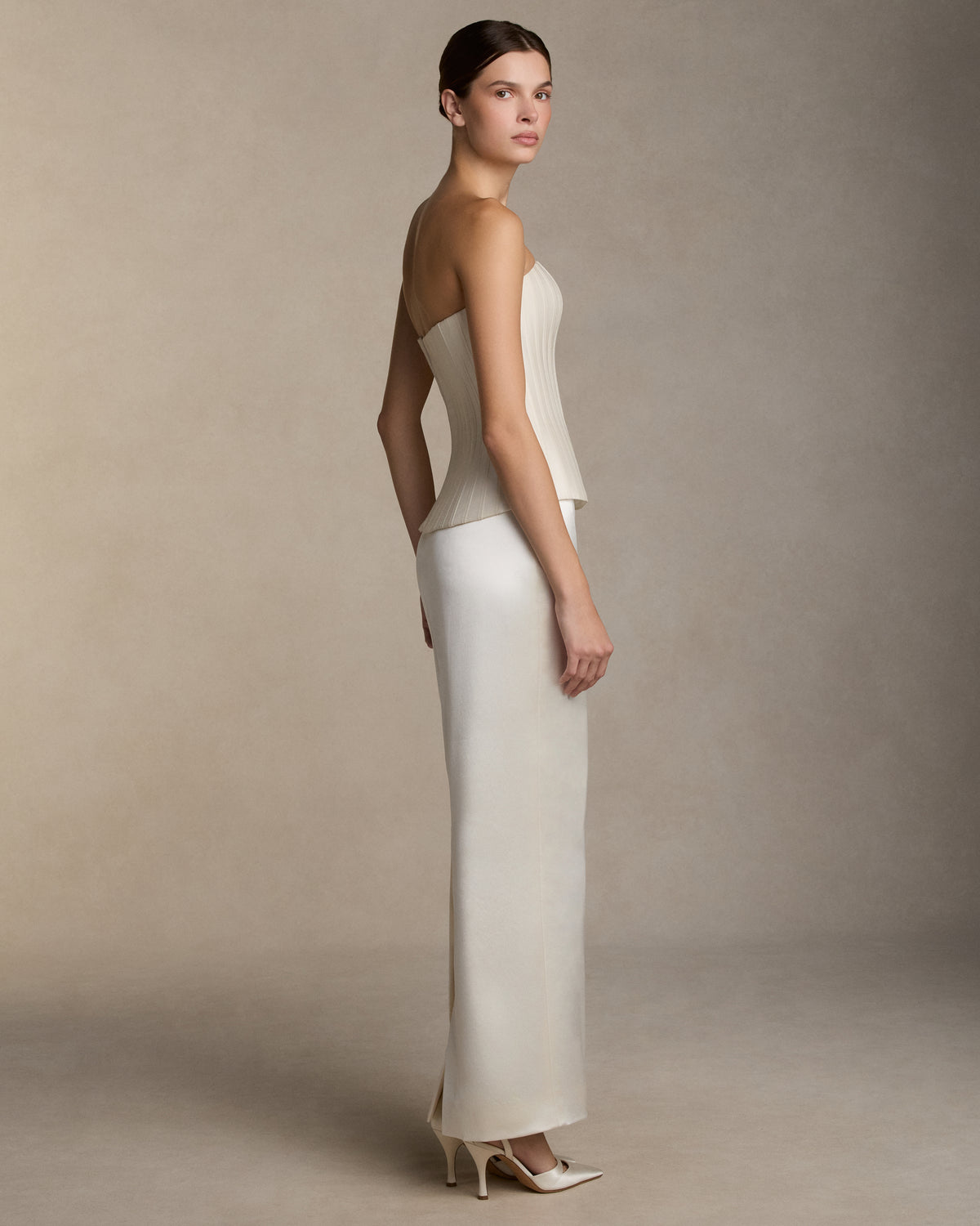 Structured silk wool twill strapless bustier with sharp waistline. Grosgrain boning detail throughout the bodice frames the silhouette. Boned internal bustier, internal grosgrain belt and invisible zip closure at center back.Styled with Tristan skirt