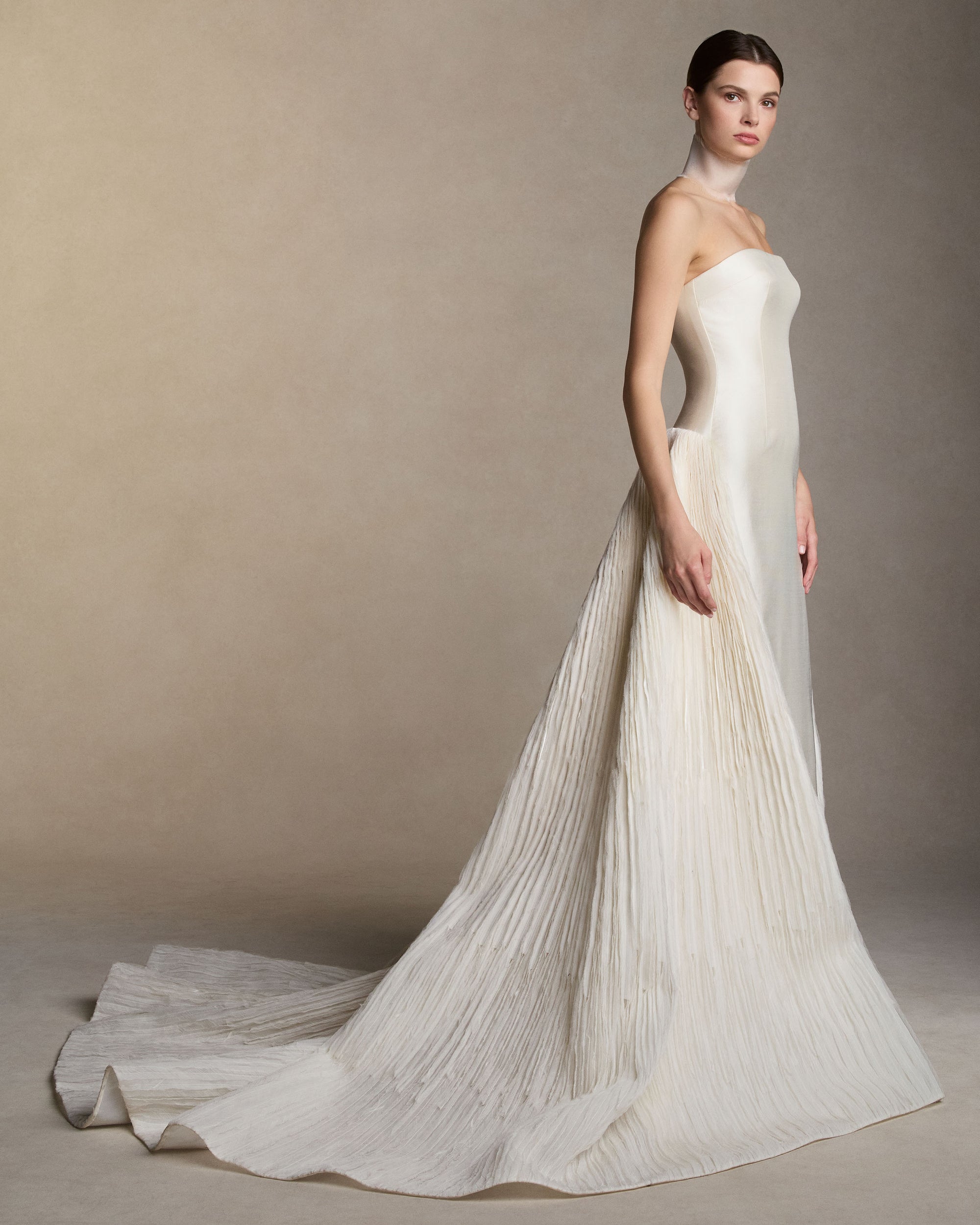Silk wool twill column gown with dramatic trompe l'oeil  ball skirt.  Radiating embroidery of stripped crinkle organza, satin organza and silk and wool falls from center back. Boned internal bustier with internal grosgrain waistbelt and  invisible zip closure at center back. 
