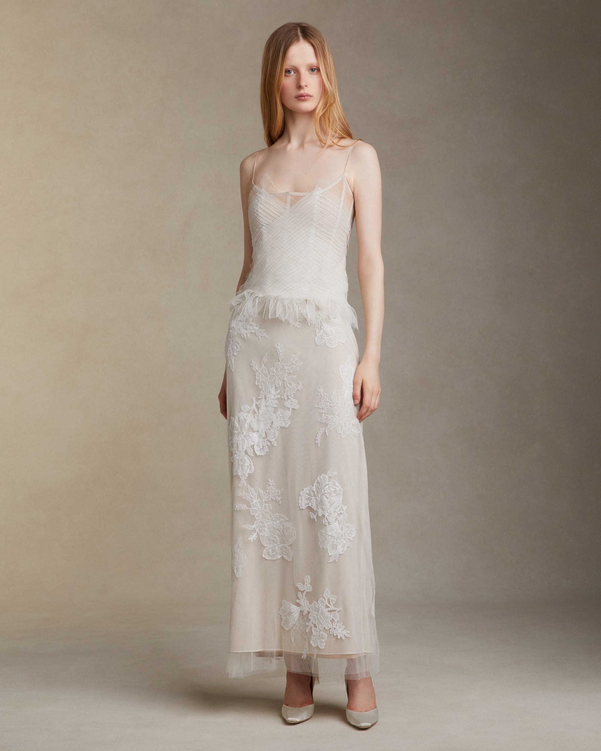 Camisole bustier top suspended by delicate spaghetti straps. Picot tulle ribbons criss cross across bodice, falling organically over hem. Boned corset revealed at center back. Center back zip closure.Styled with Theo SkirtStyled with Georgia Skirt