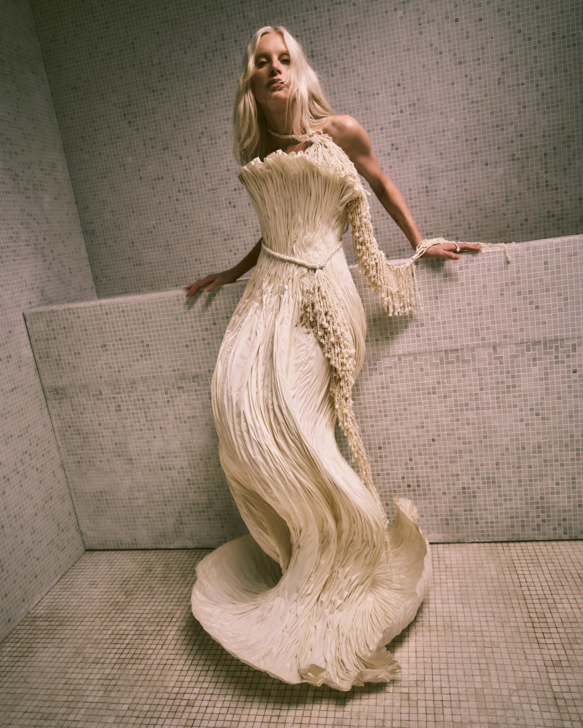 Strapless tissue taffeta ballgown with flared neckline and sculptural shaping created with hundreds of rows of micro boning that twist and curve around the body. Boned internal bustier, internal grosgrain belt and invisible zip closure at center back.