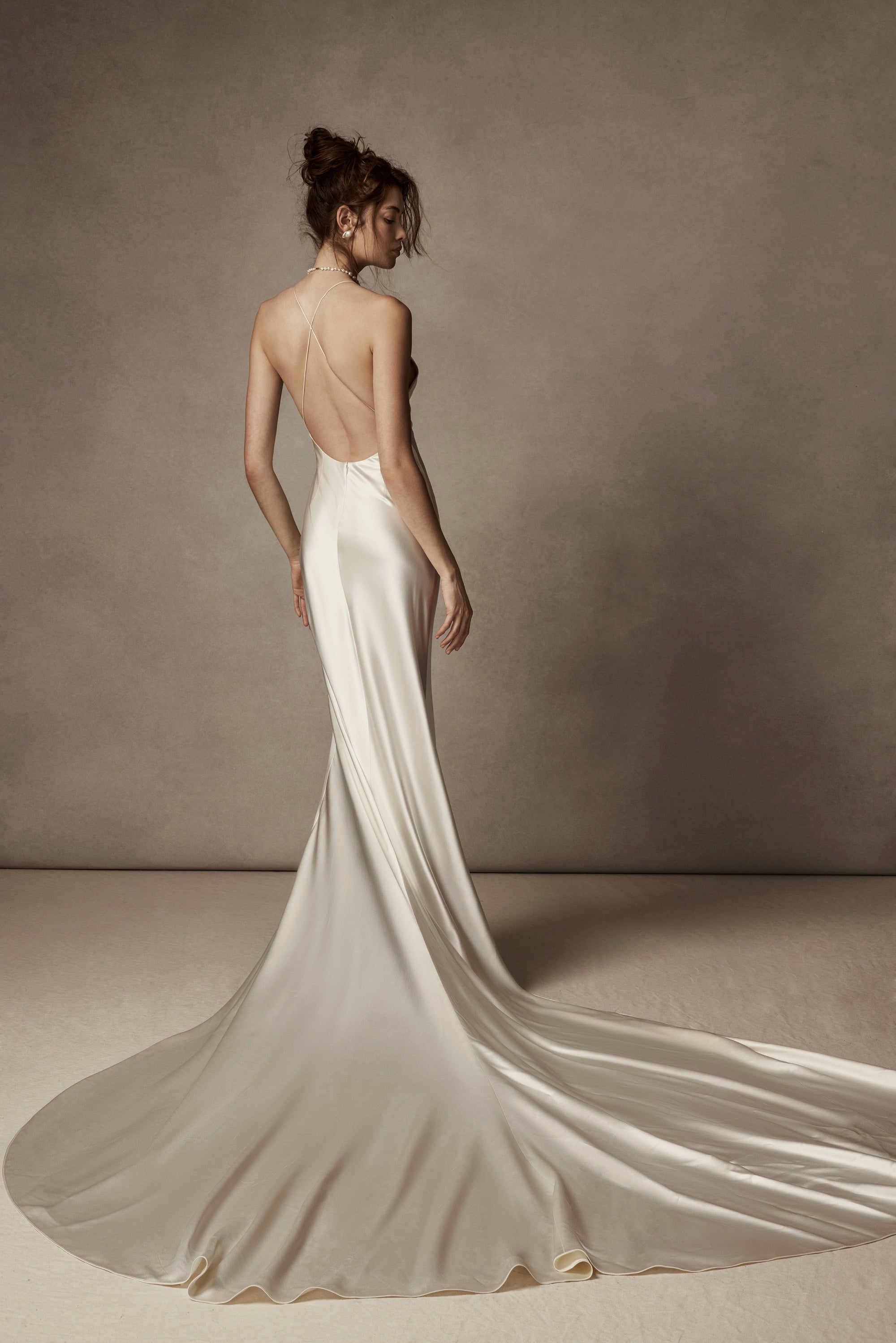 Cowled neck, crepe back satin slip gown. Low scooped back with cross back spaghetti straps. Detachable tulle cape with hand appliquéd chantilly lace edging along sides. Center back zip, hook and eye closure.