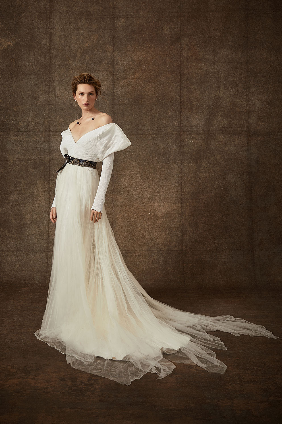 Off-shoulder gown with mini-pleated Georgette draped sleeves, and Grosgrain waist detail. Smooth faced Cady skirt, with circular train.Styled with Charlotte Skirt, Python Belt with Pearl Buckle and Flaired Baroque Pearl Drop Earrings.