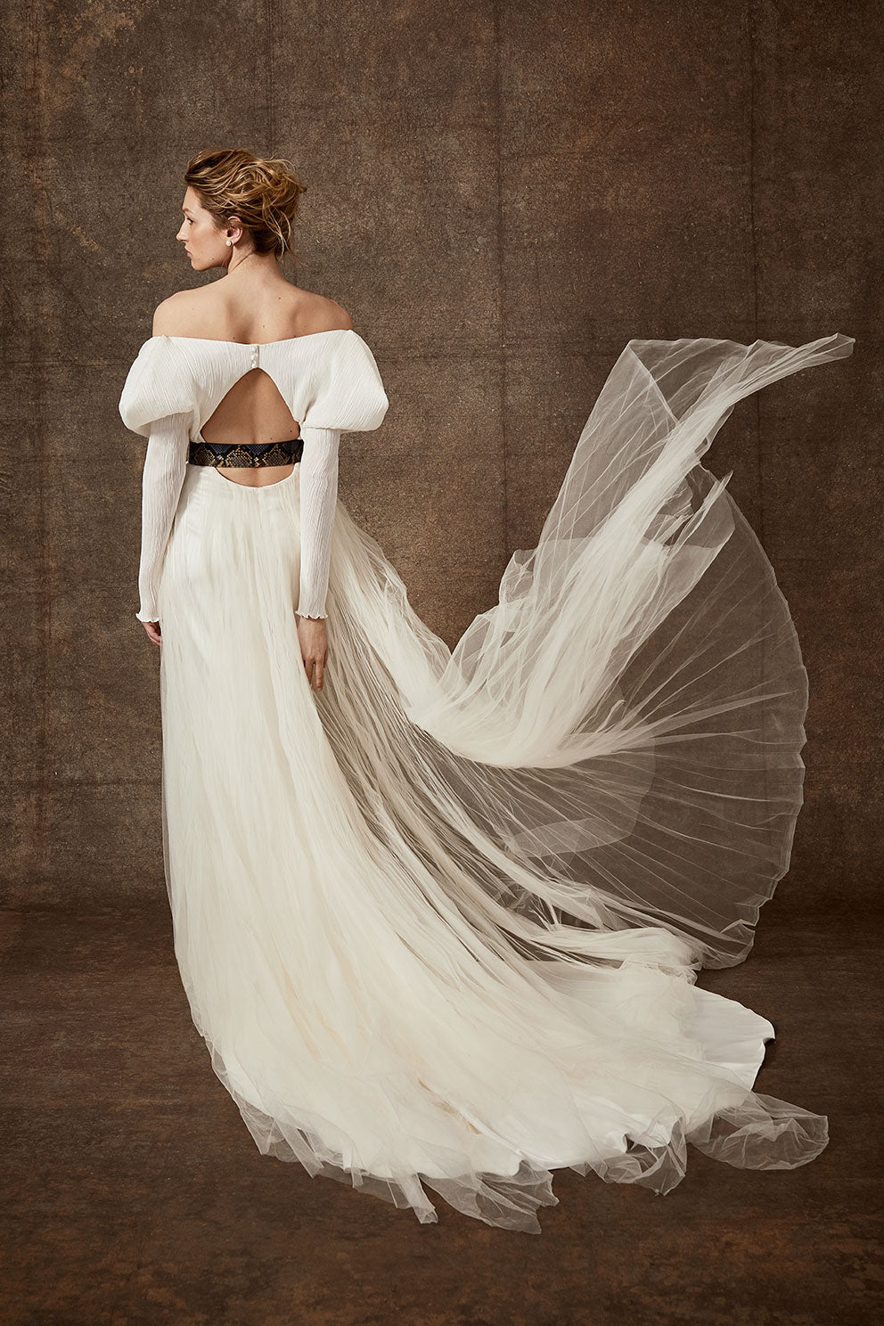 Off-shoulder gown with mini-pleated Georgette draped sleeves, and Grosgrain waist detail. Smooth faced Cady skirt, with circular train.Styled with Charlotte Skirt, Python Belt with Pearl Buckle and Flaired Baroque Pearl Drop Earrings.