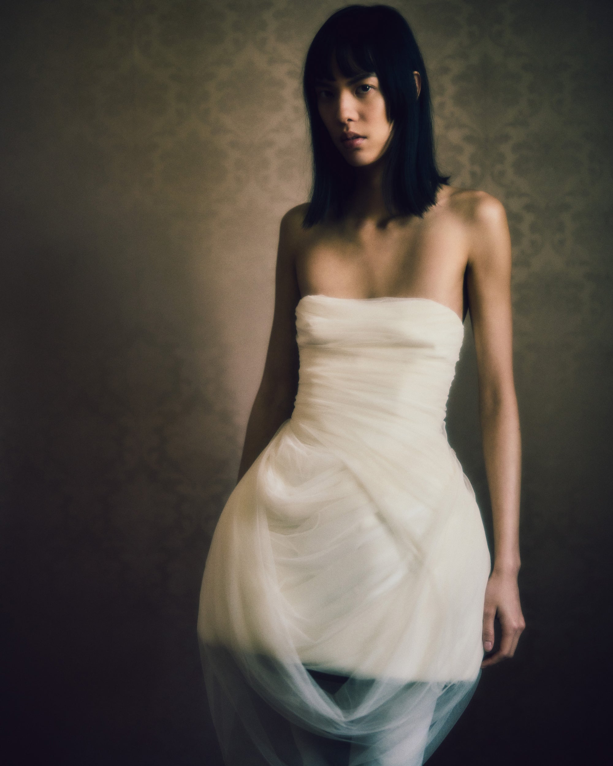 Strapless structured Cady mini dress with draped soft tulle overlay. Layers of tulle draping cascade into a swagged front skirt and dip at back to reveal boned organza bustier. Center back zip closure.