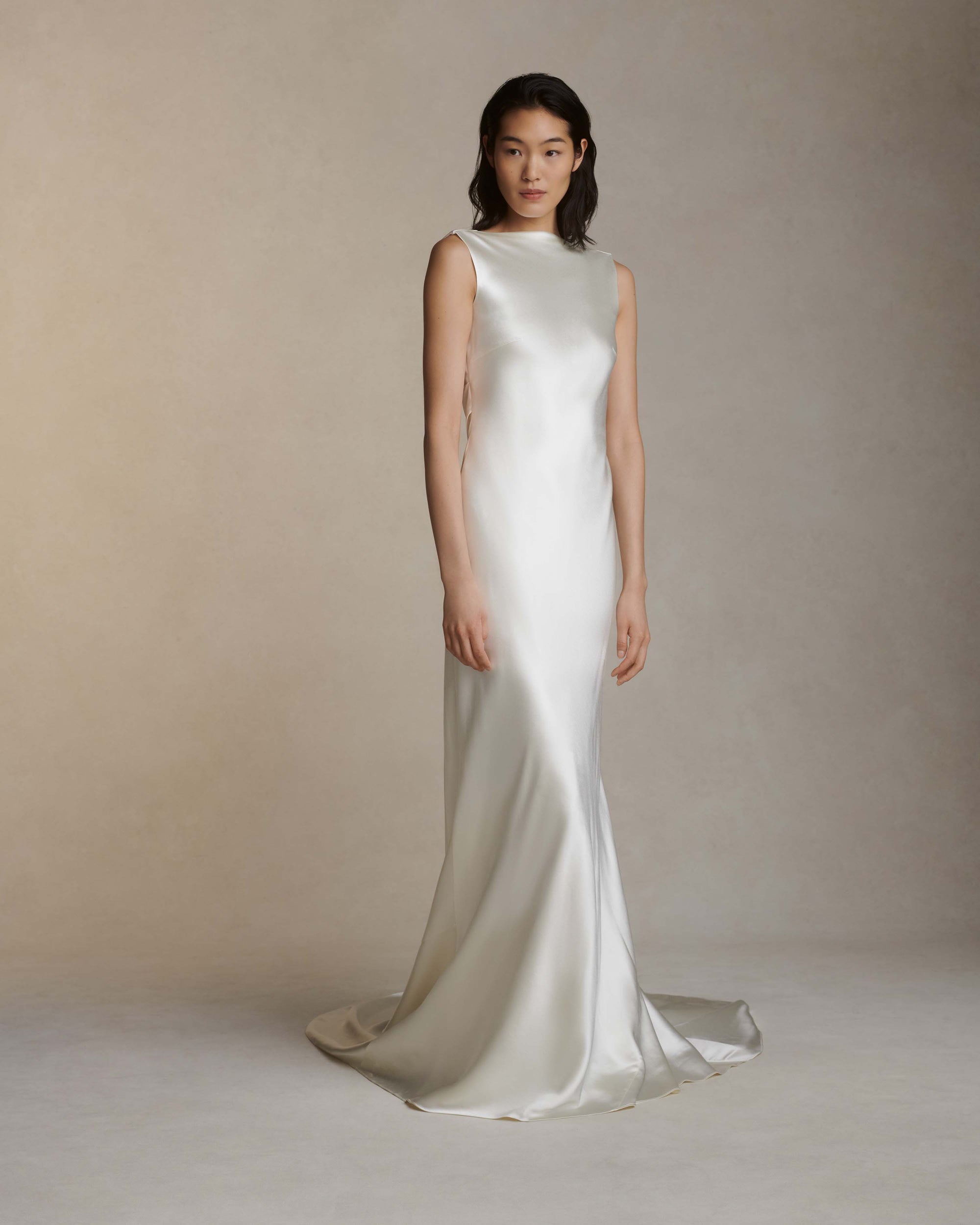 Raised cowl neck, bias cut silk wool sleeveless gown. Open back with scarf draped accent. Fully lined with side zip closure.Styled with Rebecca lace bolero