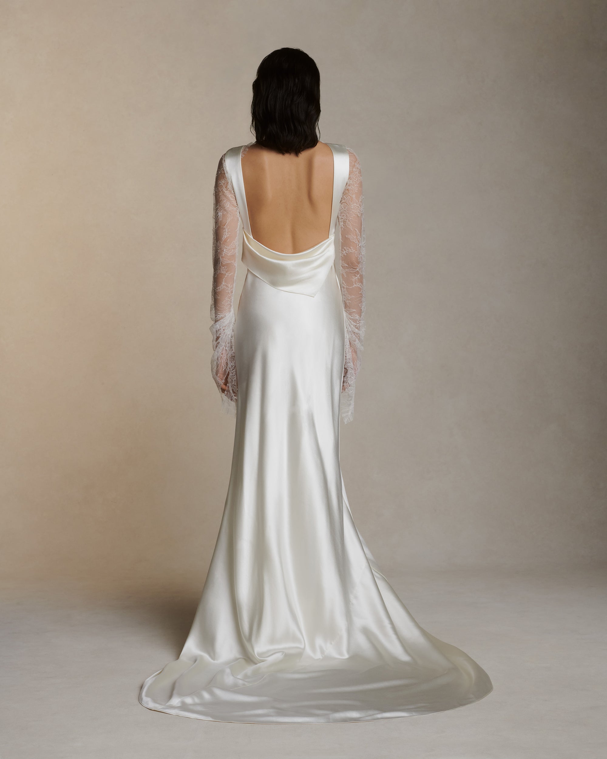 Raised cowl neck, bias cut silk wool sleeveless gown. Open back with scarf draped accent. Fully lined with side zip closure.Styled with Rebecca lace bolero