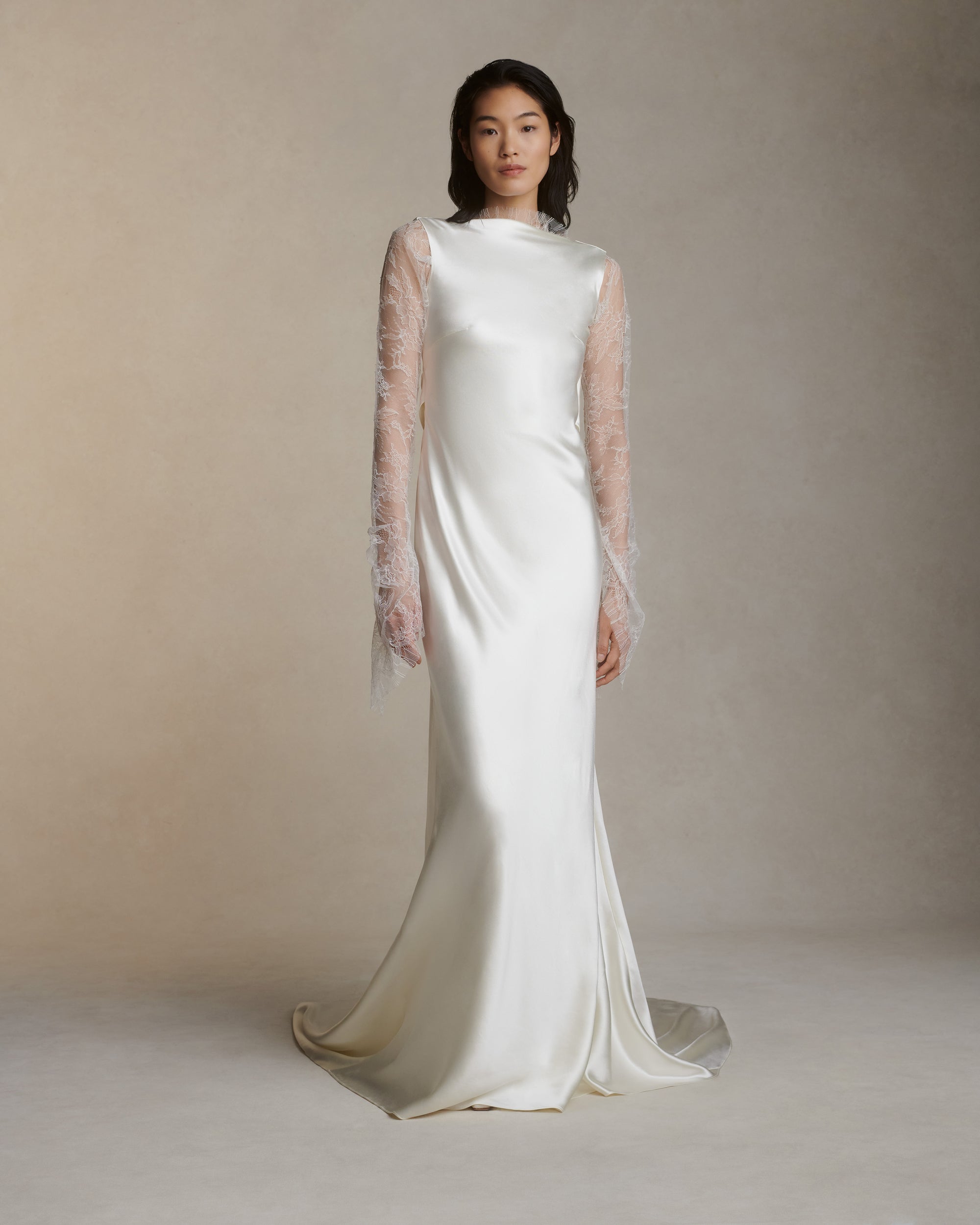 Raised cowl neck, bias cut silk wool sleeveless gown. Open back with scarf draped accent. Fully lined with side zip closure.Styled with Rebecca lace bolero