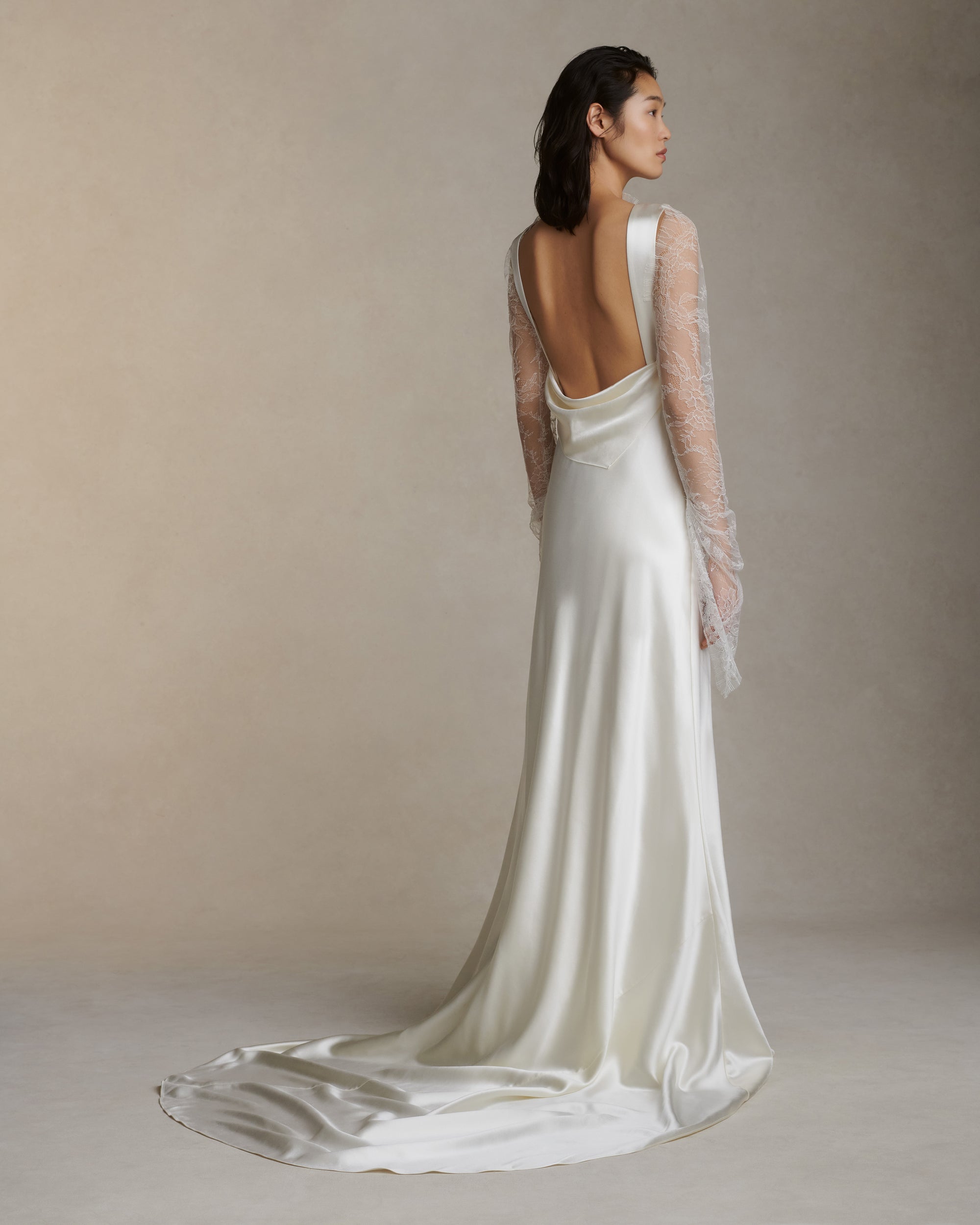 Raised cowl neck, bias cut silk wool sleeveless gown. Open back with scarf draped accent. Fully lined with side zip closure.Styled with Rebecca lace bolero