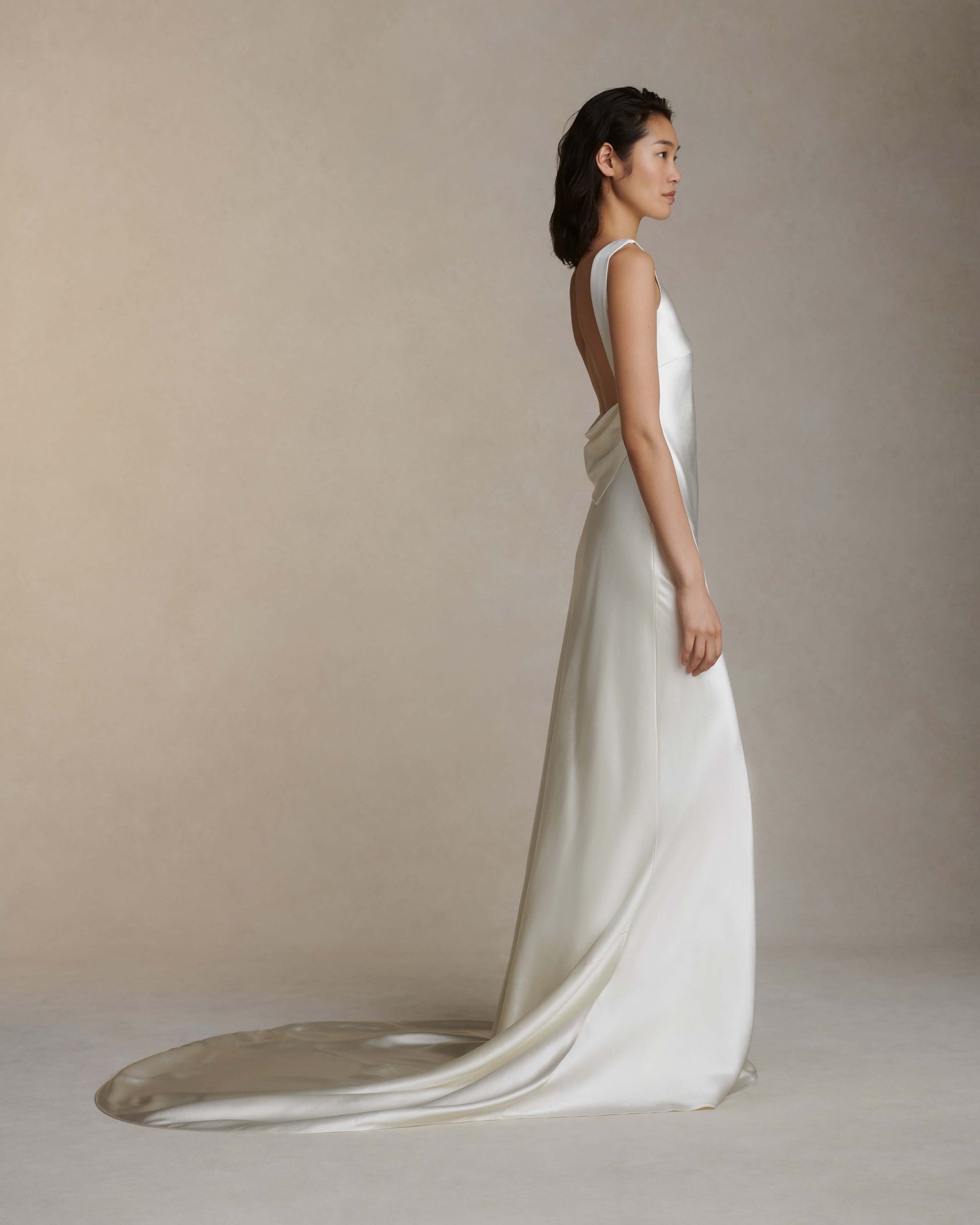 Raised cowl neck, bias cut silk wool sleeveless gown. Open back with scarf draped accent. Fully lined with side zip closure.Styled with Rebecca lace bolero