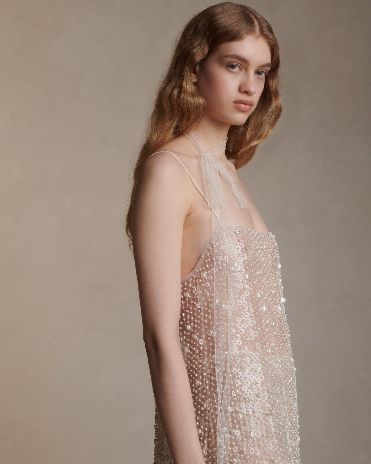 Air organza shift mini dress with soft square neckline suspended from delicate spaghetti straps. Hand embroidered with genuine baroque pearls and transparent sequins throughout. Center back zip closure. Unlined.   Styled with Lenny skirt
