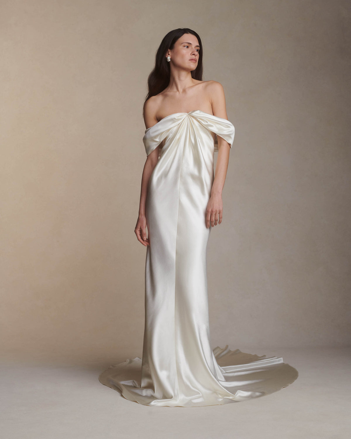 Off the shoulder silk wool gown with elegant draping at center front releasing into swagged sleeve detail. Boned internal bustier with soft cups, internal grosgrain waist belt and invisible side zip closure. 