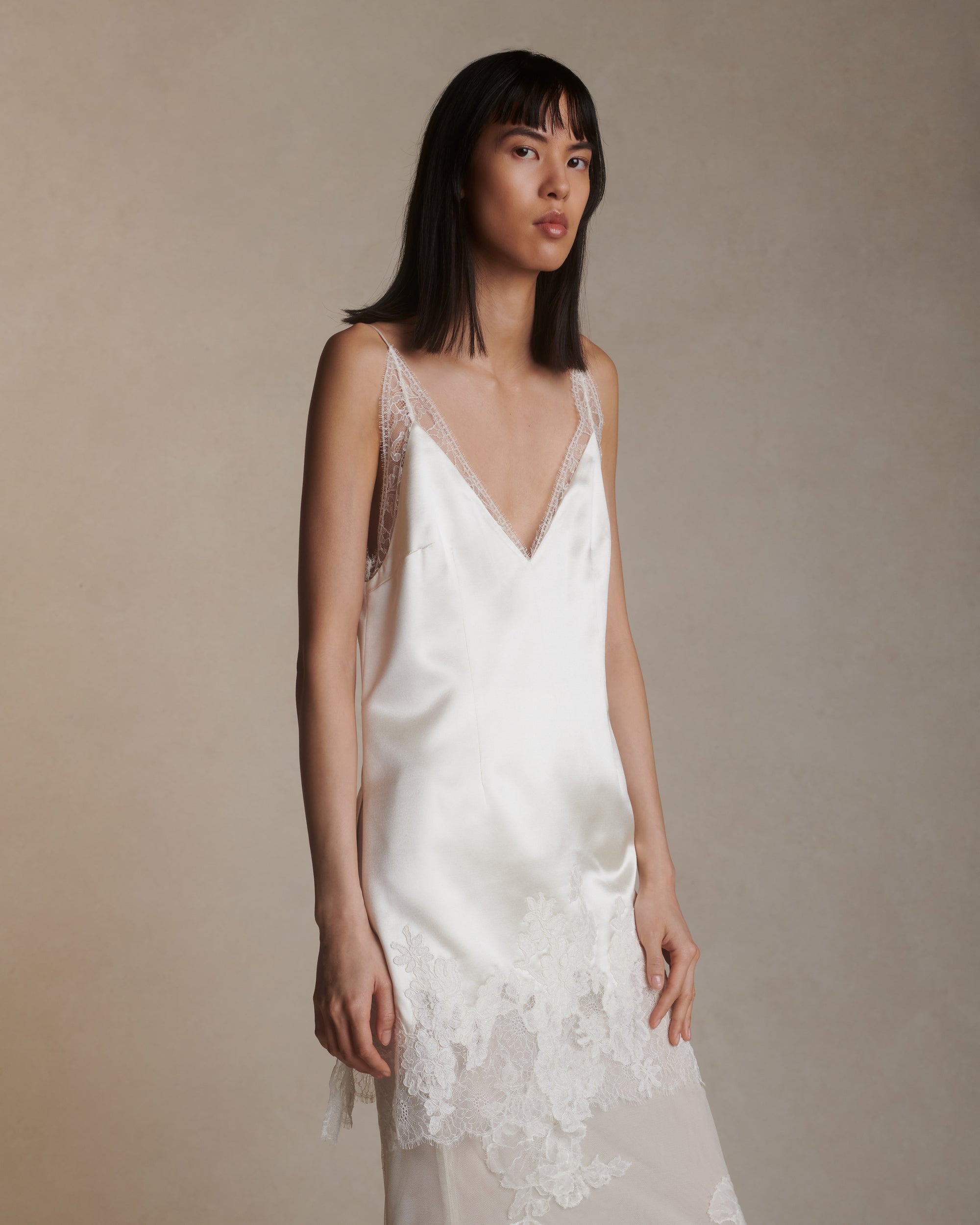 Silk column skirt with two layers of soft tulle adorned in hand cut corded and chantilly lace applique. Invisible side zip closure.Styled with Dan mini dress