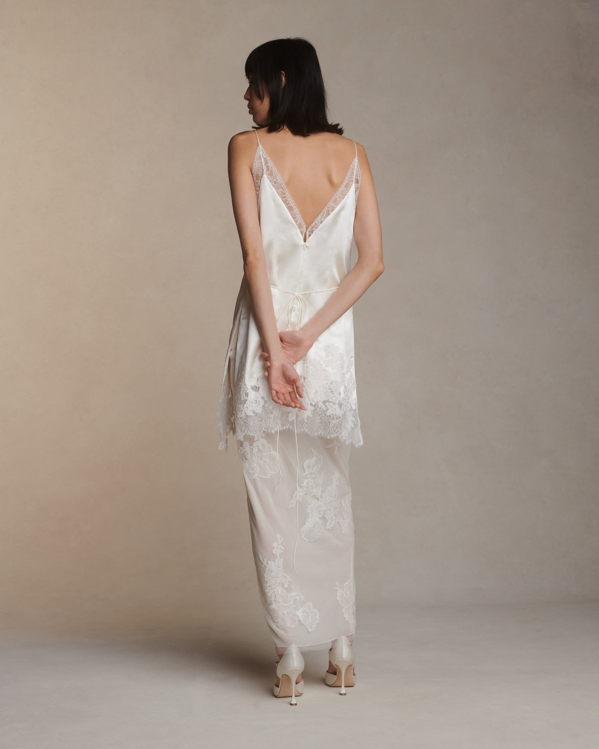 Silk column skirt with two layers of soft tulle adorned in hand cut corded and chantilly lace applique. Invisible side zip closure.Styled with Dan mini dress