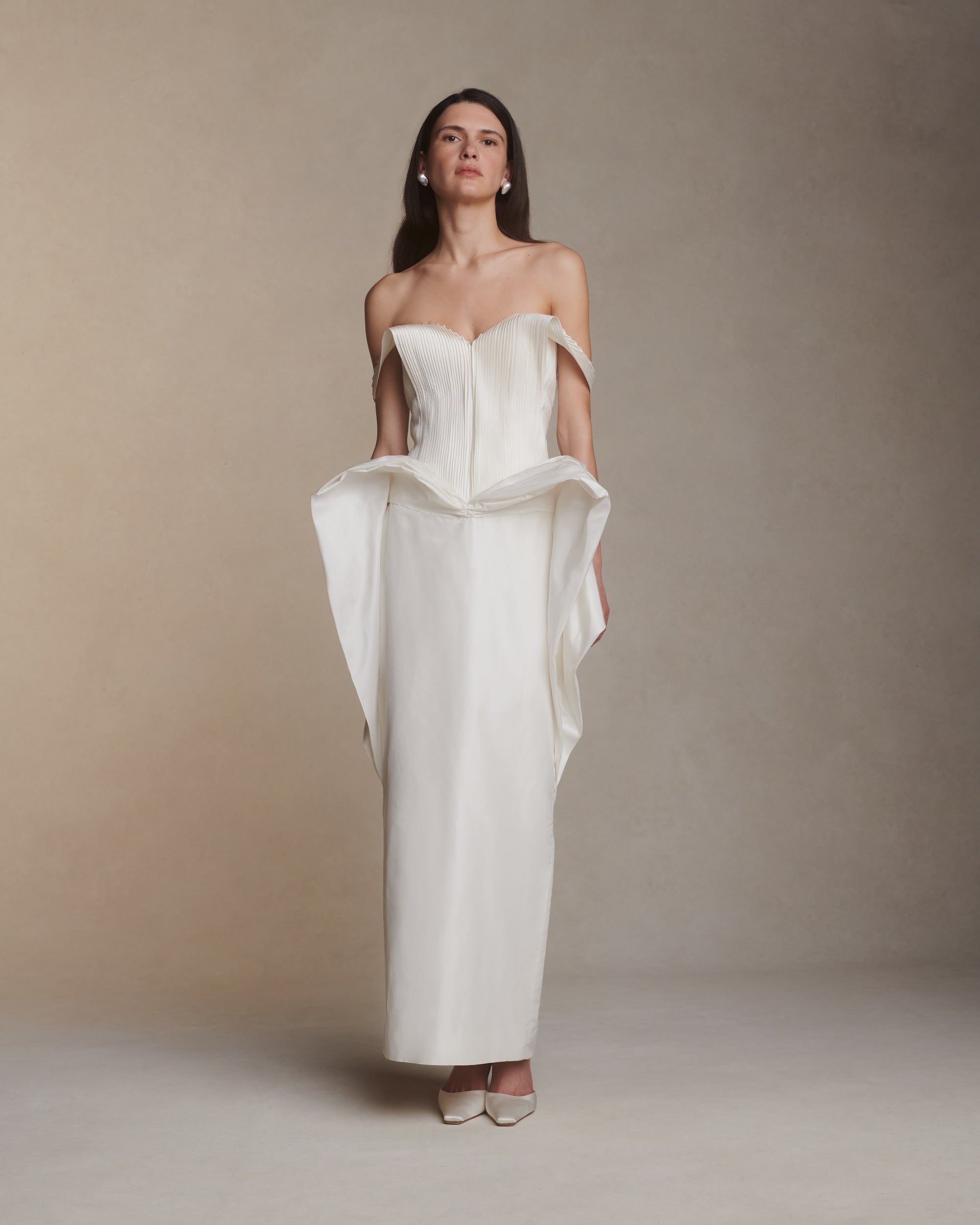 Structured hand tucked silk taffeta strapless dress with piqued bust, exaggerated waist drape and column skirt. Micro tucked panels drape delicately over arms and secure with a spaghetti tie at back. Boned internal bustier with soft cups, invisible center back zip closure.