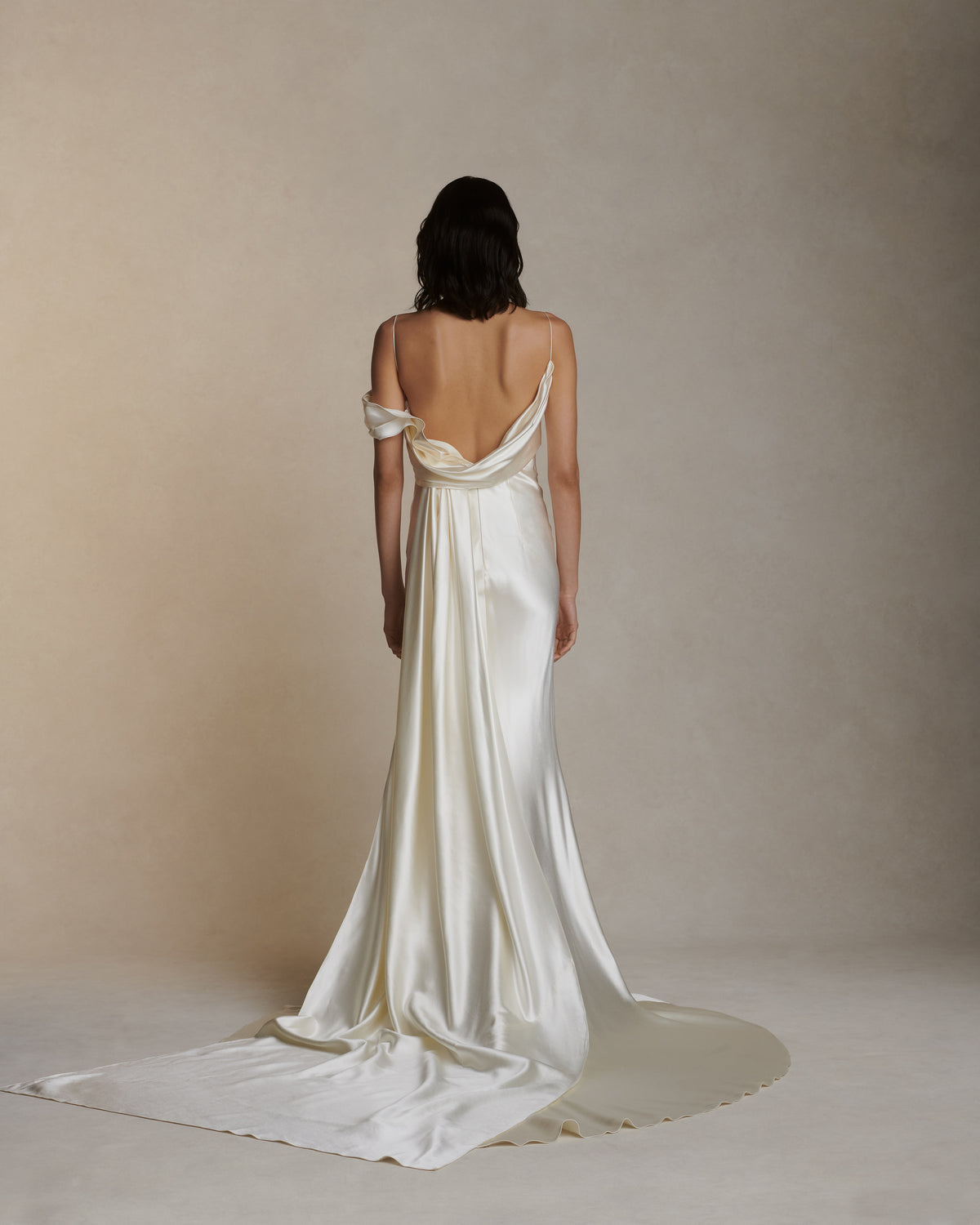 Pendulous, asymmetrical draped silk wool bias cut gown. Sweeping cowl back with detachable watteau train. Soft internal bustier with side boning, cups, and grosgrain belt with 3 hook position. Low center back zip, hook and eye closure.