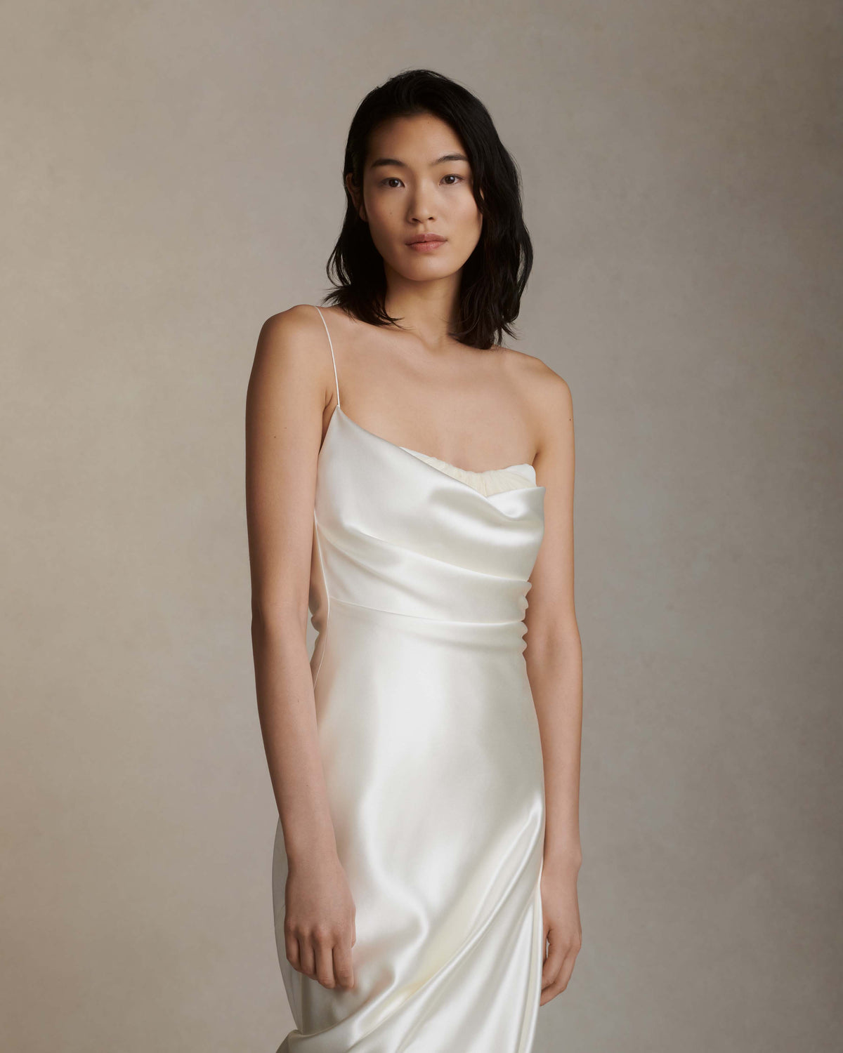 Layered silk wool and soft tulle gown. Fluid draping spills over sunburst pleated tulle skirt with bubble hem. Dipped drape reveals delicate gathered tulle at front neckline and boned organza bustier at back. Soft cups, internal grosgrain waist belt and invisible side zip closure.