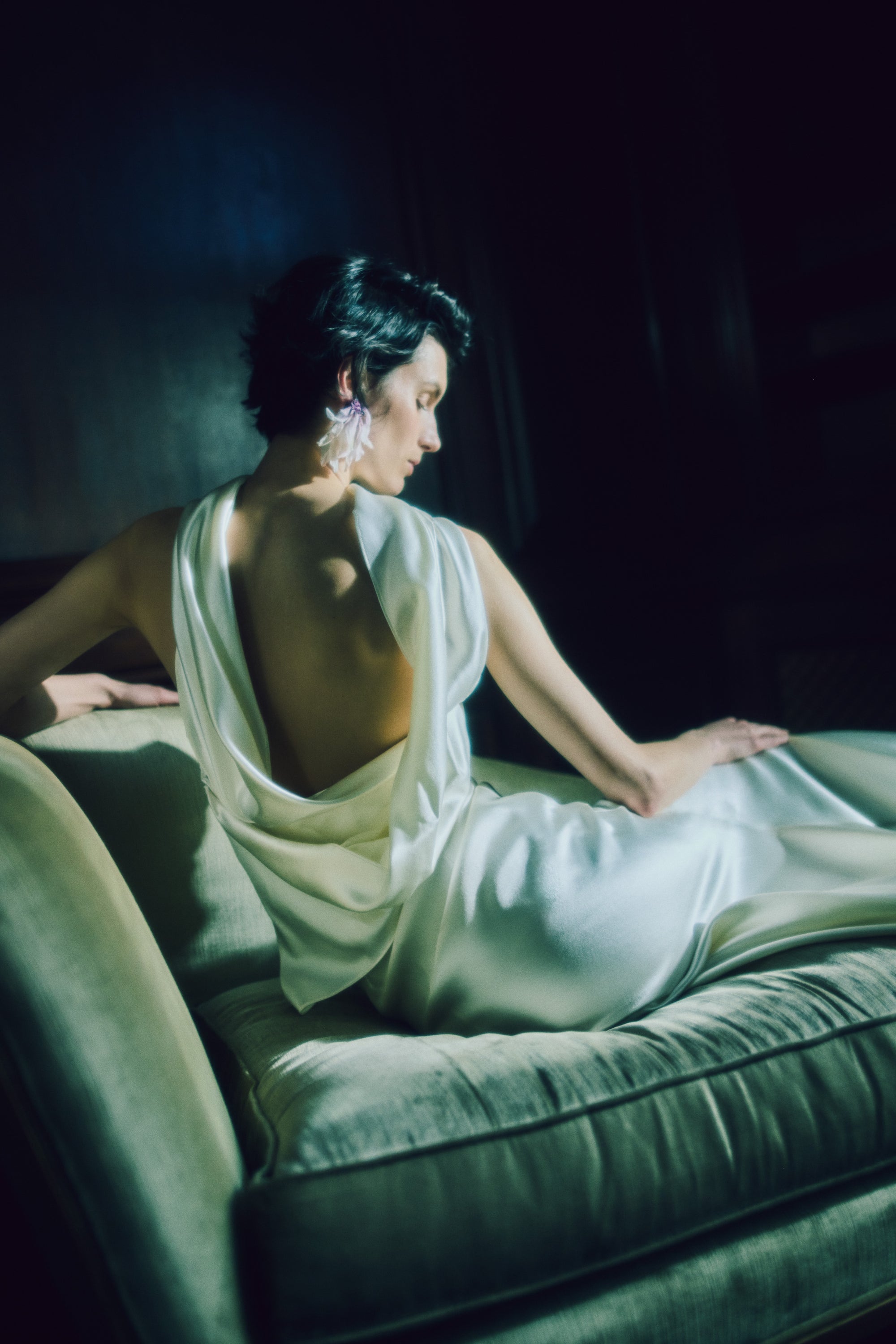 Strapless silk wool bias cut gown. Asymmetric drape wraps gracefully across neck and shoulders falling into a scarf drape detail at low back. Drape is removable with hidden covered buttons on bodice. Boned internal bustier with soft cups, internal grosgrain waist belt and invisible side zip closure.