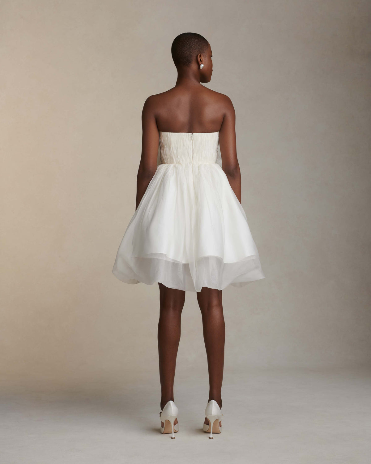 Organza petal mini dress. Dual layered with soft boning for structure, sheer organza bubbled skirt with ivory lining. Center back zip close.