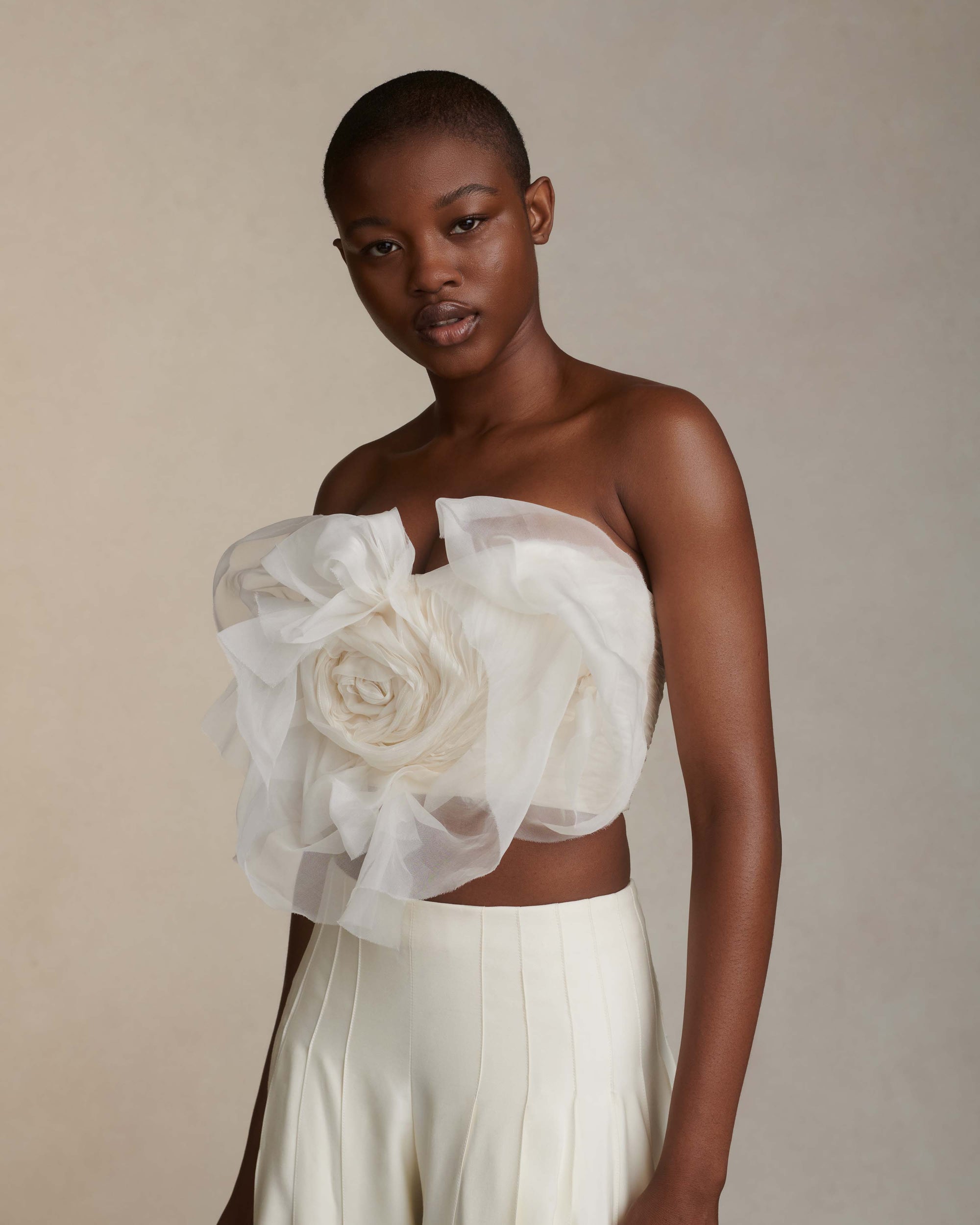 Organza petal strapless bustier. Dual layered with soft boning for structure, sheer organza petals and ivory lining. Center back zip close.Styled with Rory pant