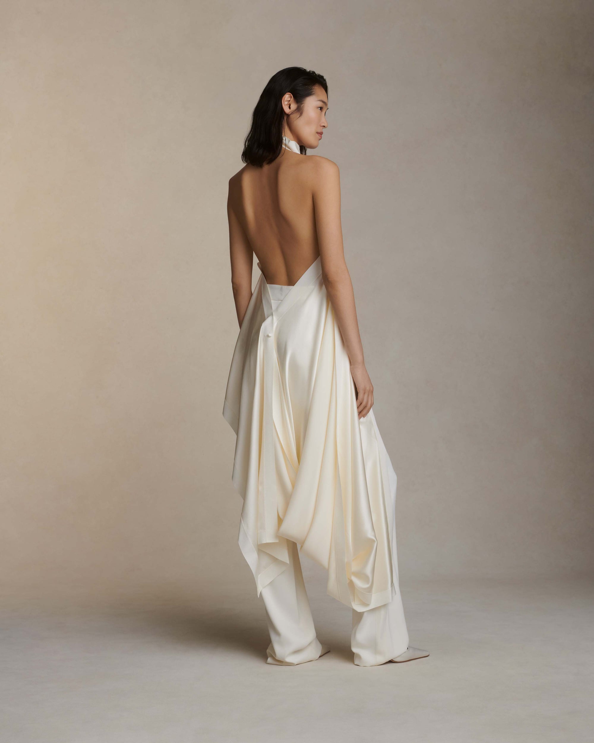 Silk crepe back satin handkerchief top. Grosgrain edging and covered button detailing along side. Optional bustle loop on handkerchief corner hem. Slip on styling with button close at neck.Styled with Miriam pant