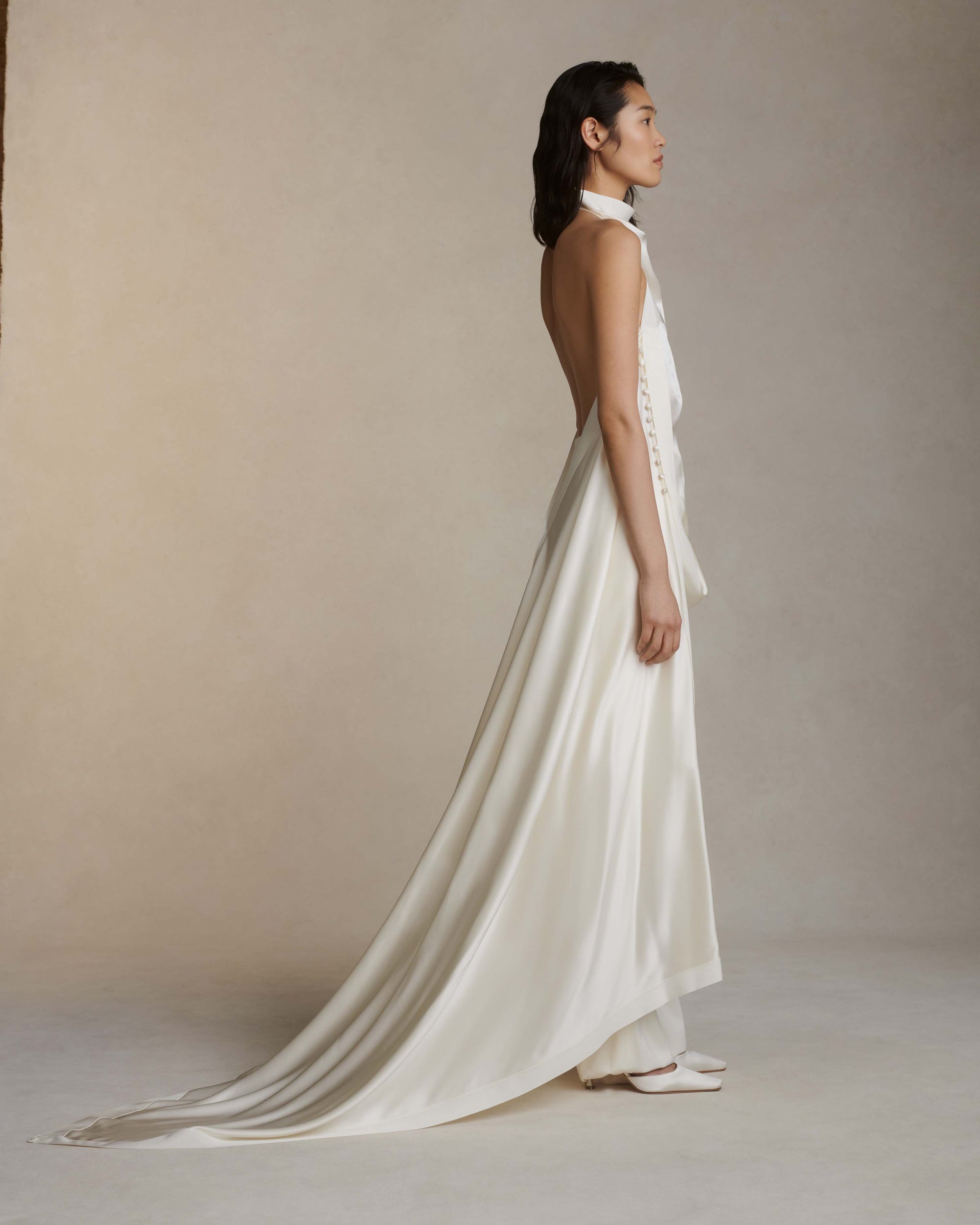Silk crepe back satin handkerchief top. Grosgrain edging and covered button detailing along side. Optional bustle loop on handkerchief corner hem. Slip on styling with button close at neck.Styled with Miriam pant