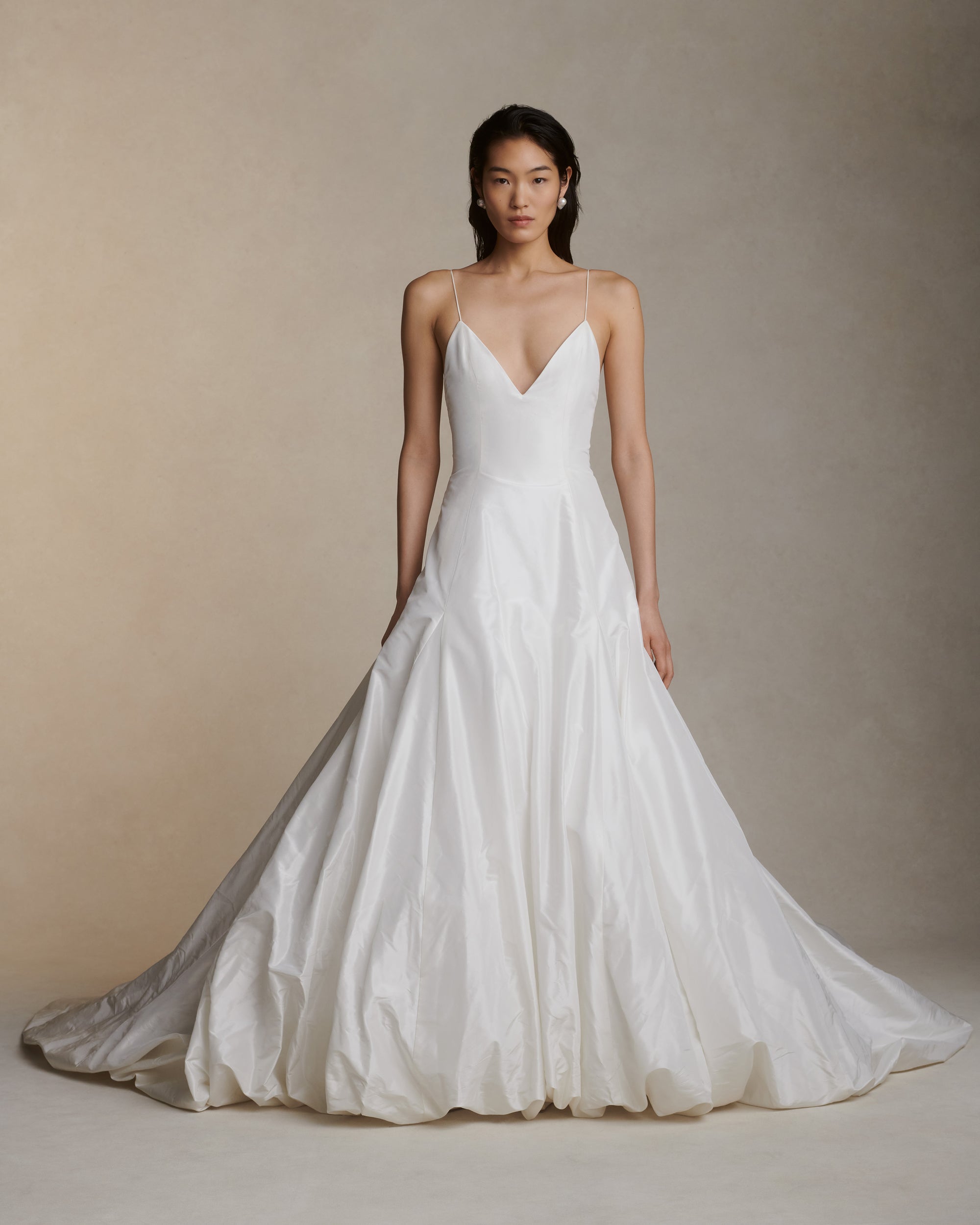 Crisp silk taffeta gown with dramatic bubbled skirt and train. Delicate spaghetti straps, deep V-neck and low V-back. Invisible zip closure at center back.