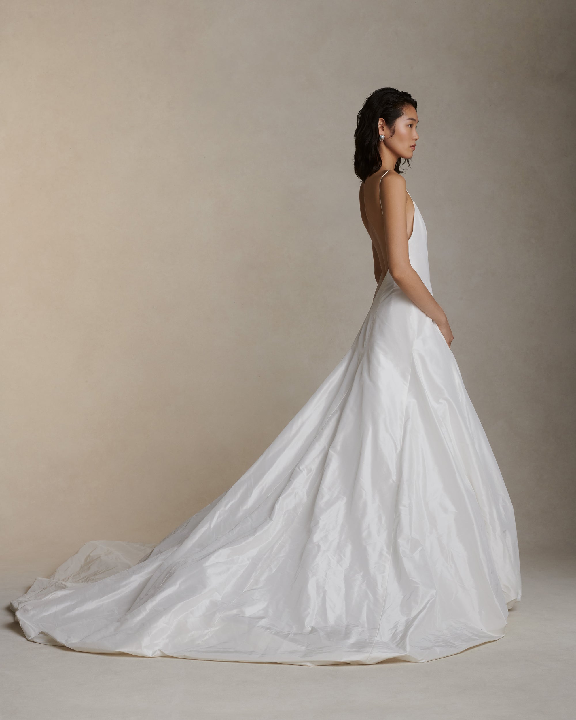 Crisp silk taffeta gown with dramatic bubbled skirt and train. Delicate spaghetti straps, deep V-neck and low V-back. Invisible zip closure at center back.