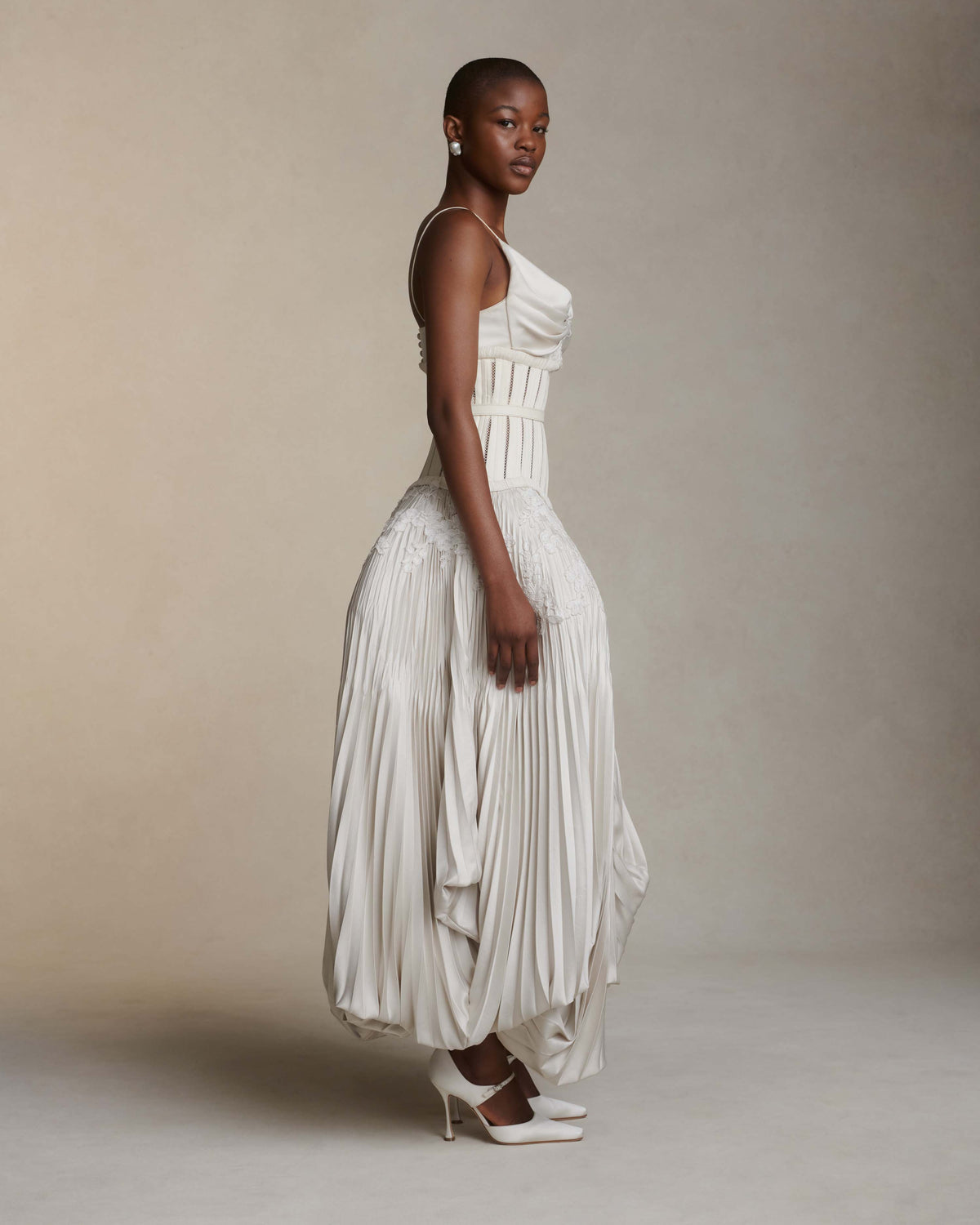 Bra: Fully structured, draped satin twill front with hand cut, hand applied corded lace with internal cups, grosgrain and four button loop closure at center back.  Skirt: Full corset with georgette trim and satin piping at seams attached to umbrella pleated skirt accented with hand cut corded lace. Hook and eye closure down center back, zipper at skirt layered over internal grosgrain waistband with three hook and bar positions. Skirt lined in organza and can can ruffle for interior construction and shaping.  